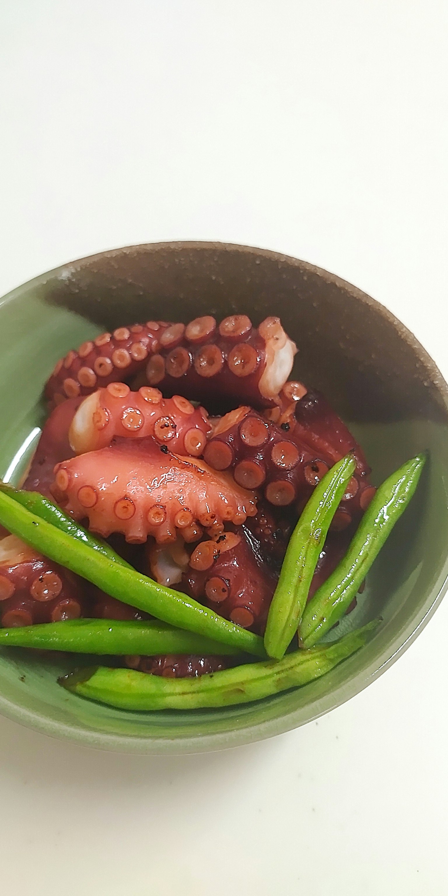 一碗配有綠色蔬菜的熟章魚