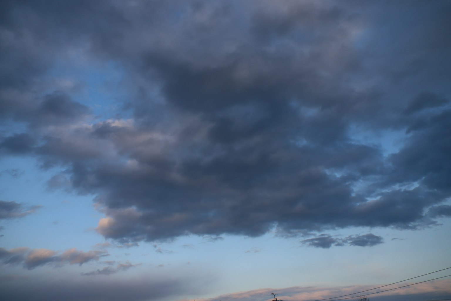 Awan gelap melayang di langit biru dengan pencahayaan senja