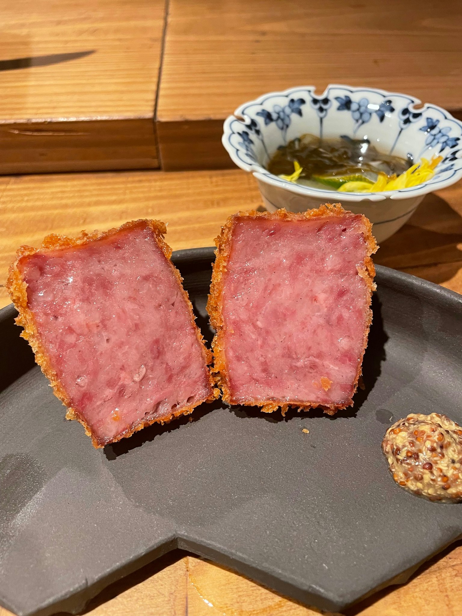 盘子上放着切好的炸火腿和蘸酱