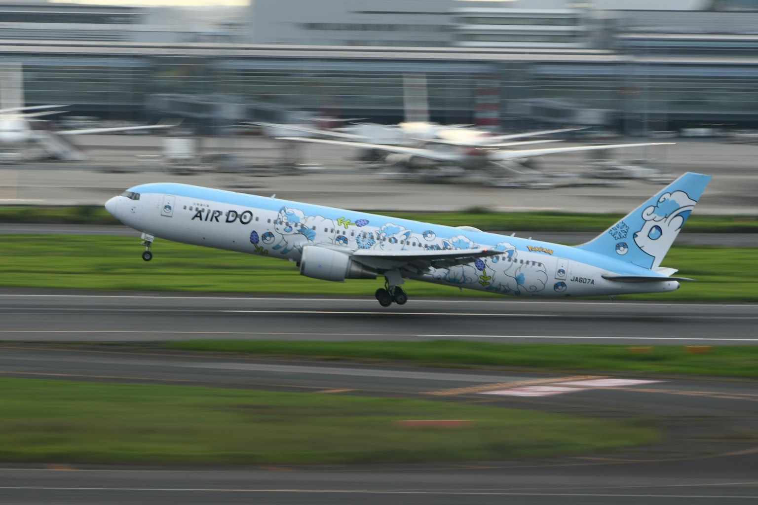 Blau gestrichenes Flugzeug startet auf der Landebahn