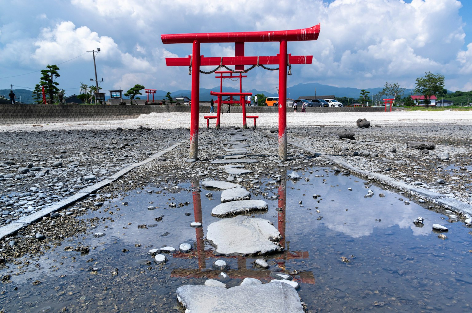 红色鸟居在水塘中的倒影和石头小路