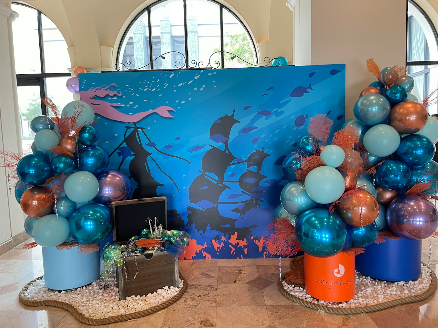 Decoración de globos con tema marino y fondo azul con cofre del tesoro