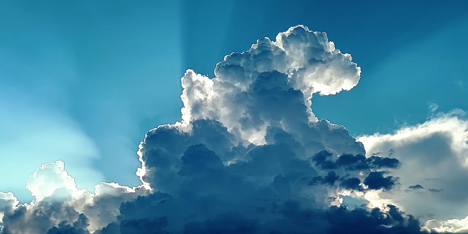 Awan putih berbulu melawan langit biru cerah dengan sinar cahaya