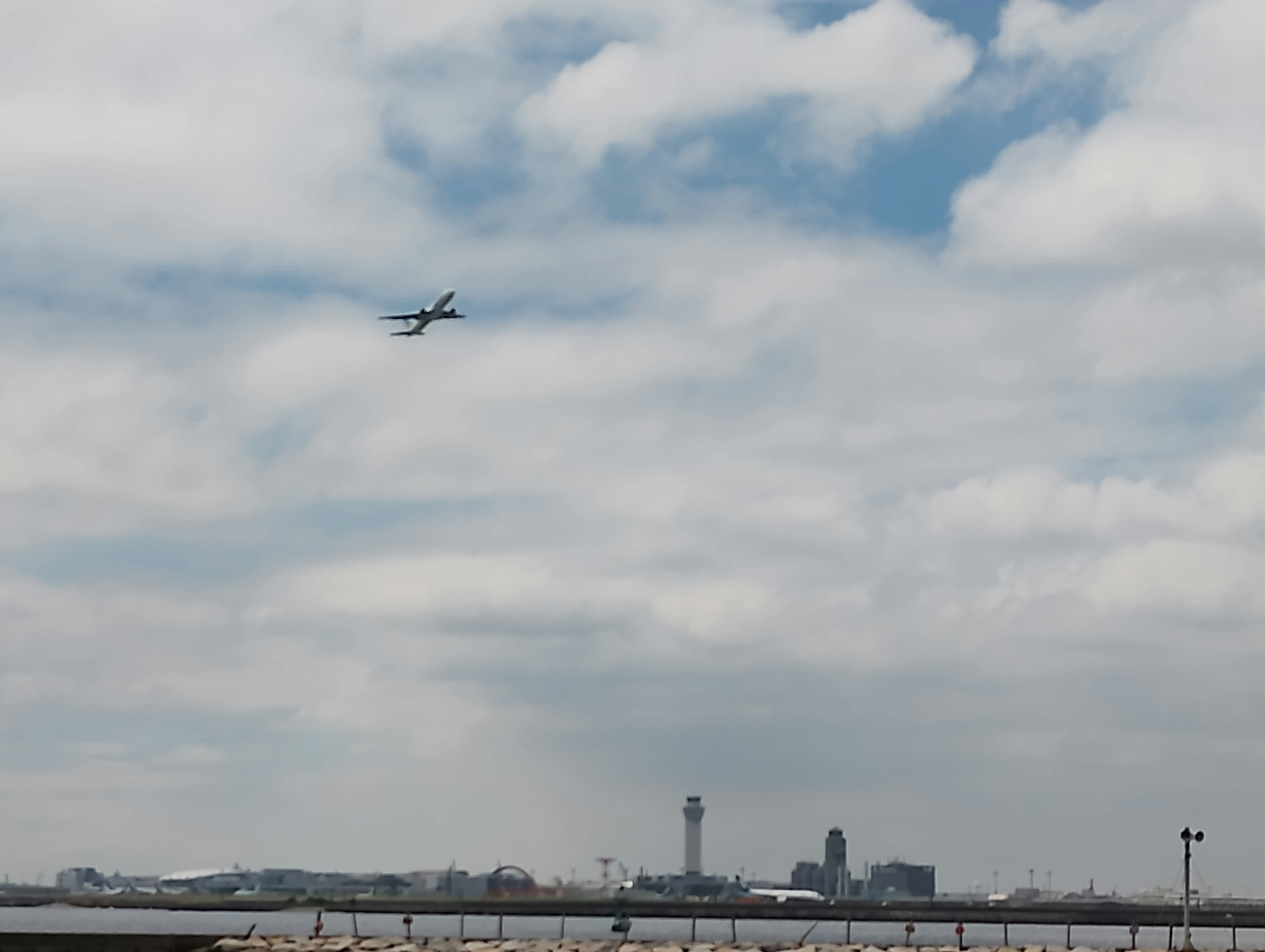 空港上空を飛ぶ飛行機と広がる空の景色