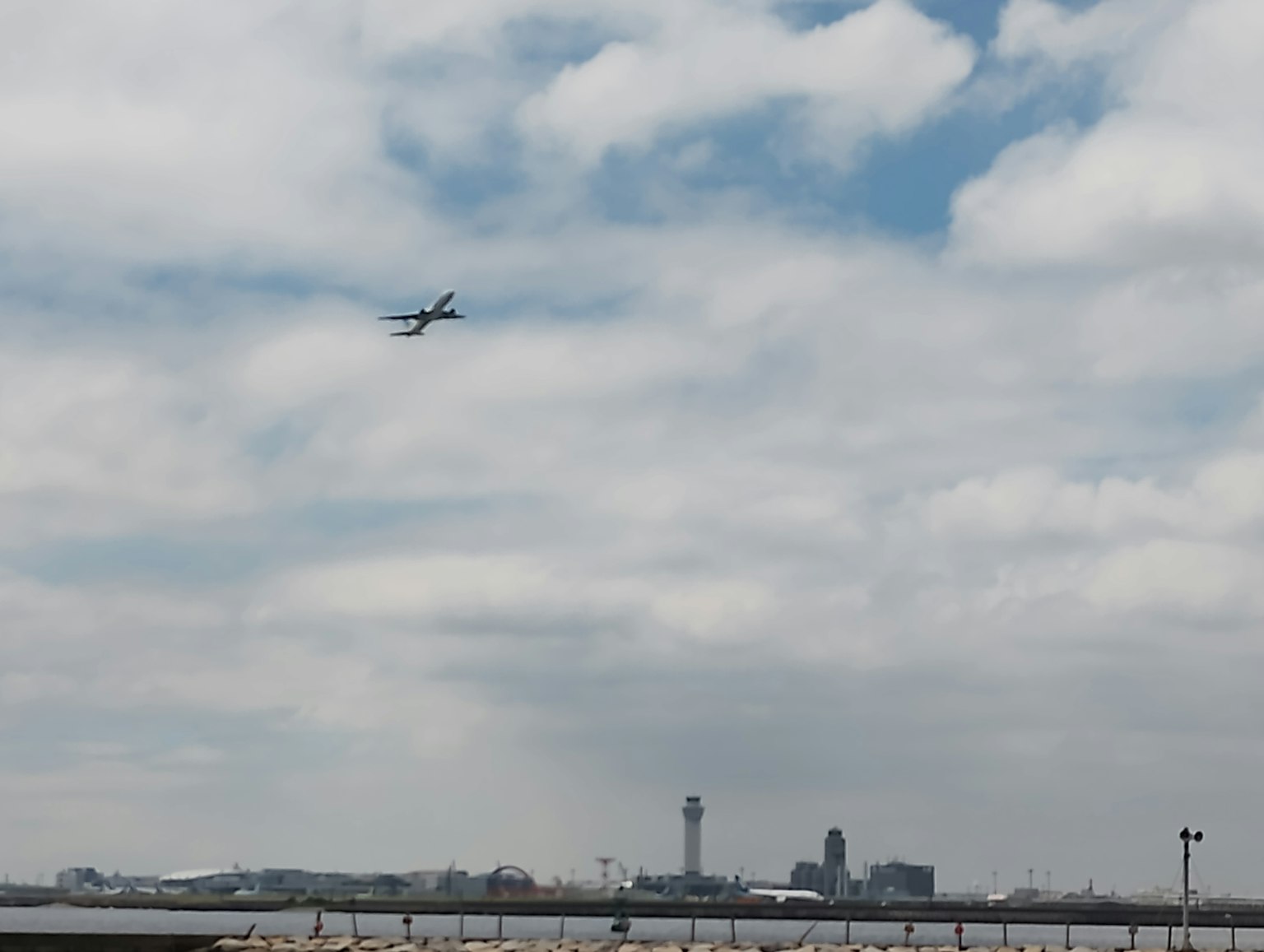 Un avión volando en el cielo con un horizonte de ciudad de fondo