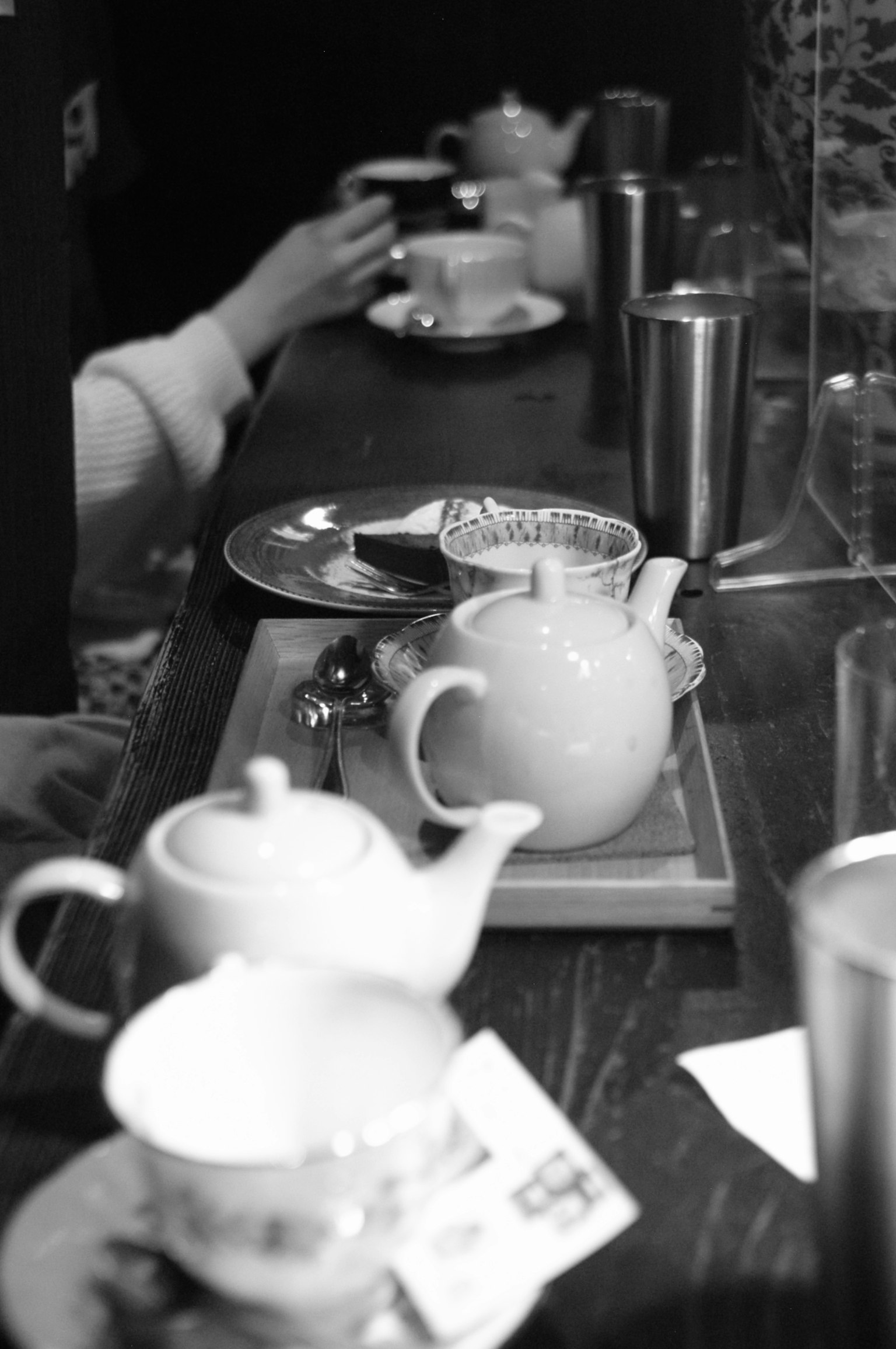 Photo en noir et blanc de théières et tasses disposées sur une table