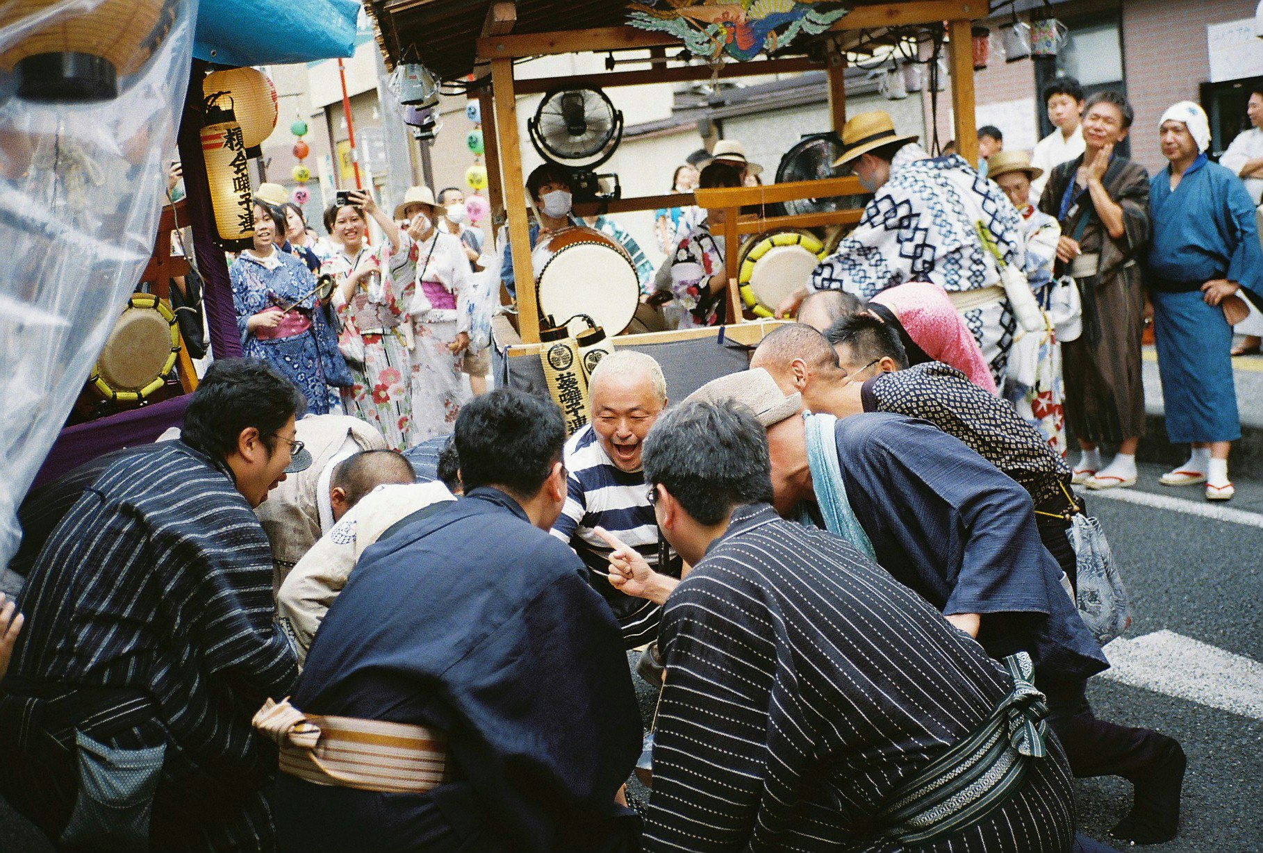 路地の屋台前で人々が行列する祭りの賑わい
