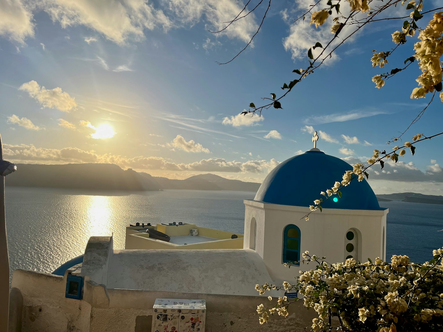 Hermoso atardecer en Santorini con iglesia de cúpula azul
