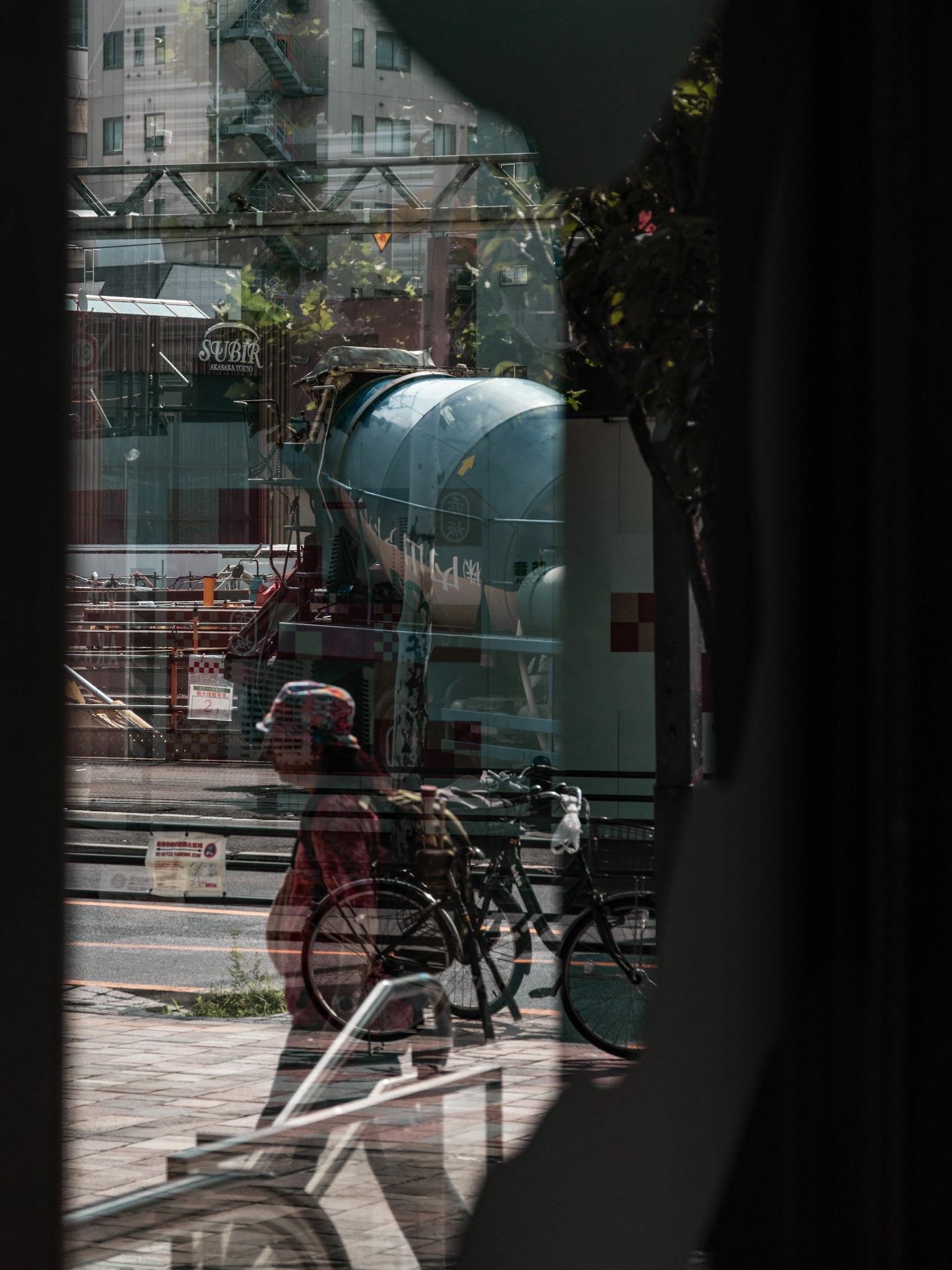 Vista di un cantiere con una persona che spinge una bicicletta attraverso una finestra