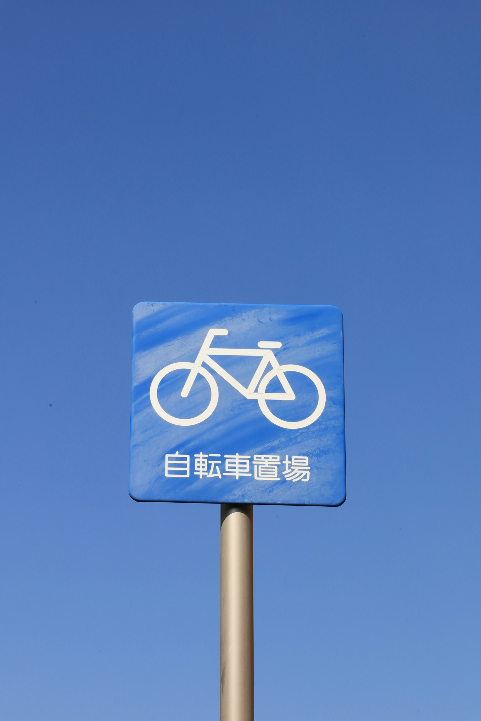藍天背景下的自行車標誌 白色自行車圖標