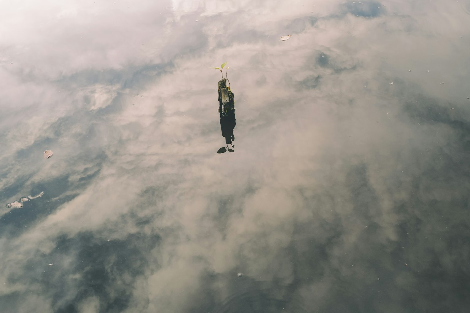 Menara kesepian berdiri melawan pantulan awan di atas air