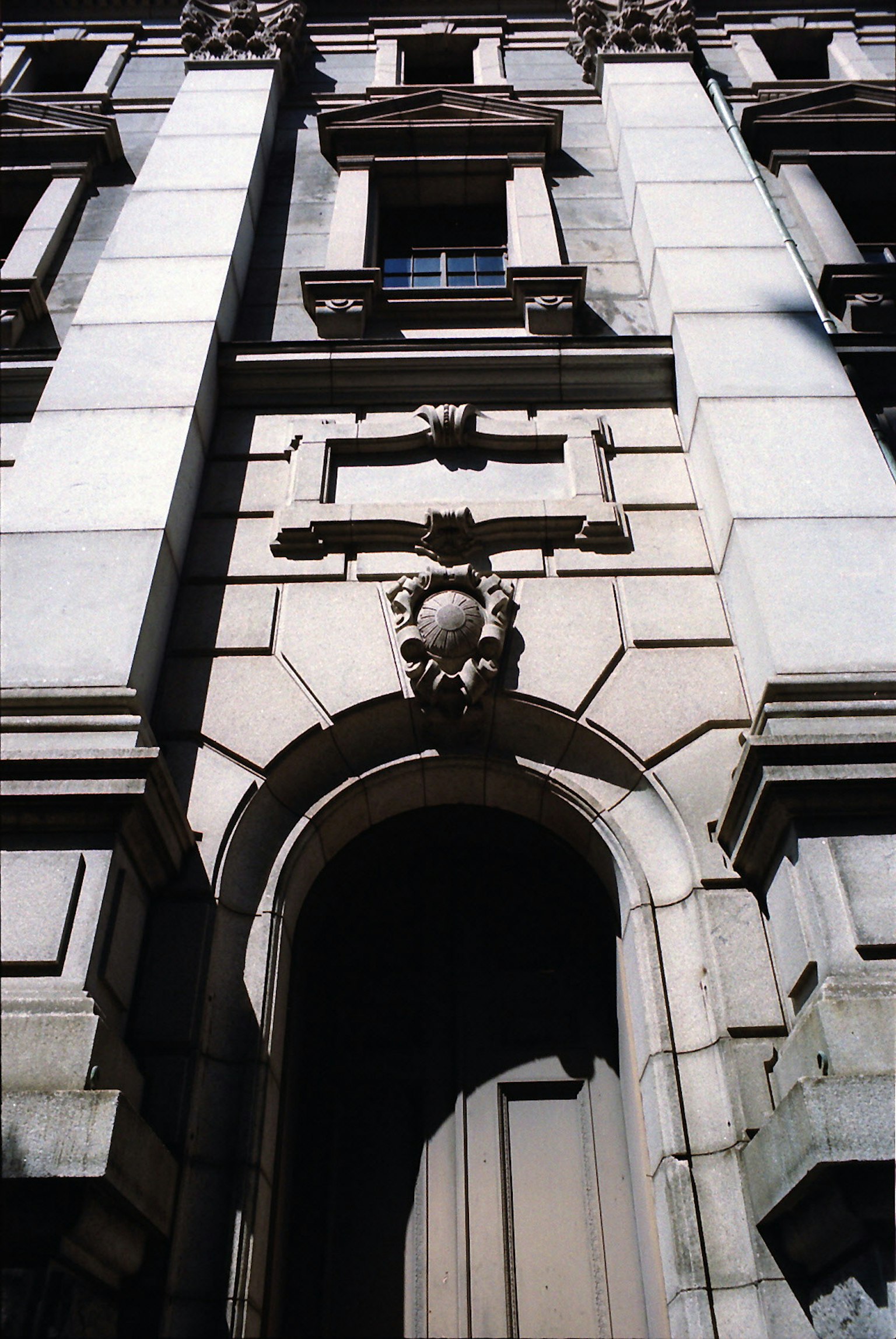 Detail einer historischen Gebäude-Fassade mit dekorativem Bogen und Skulptur
