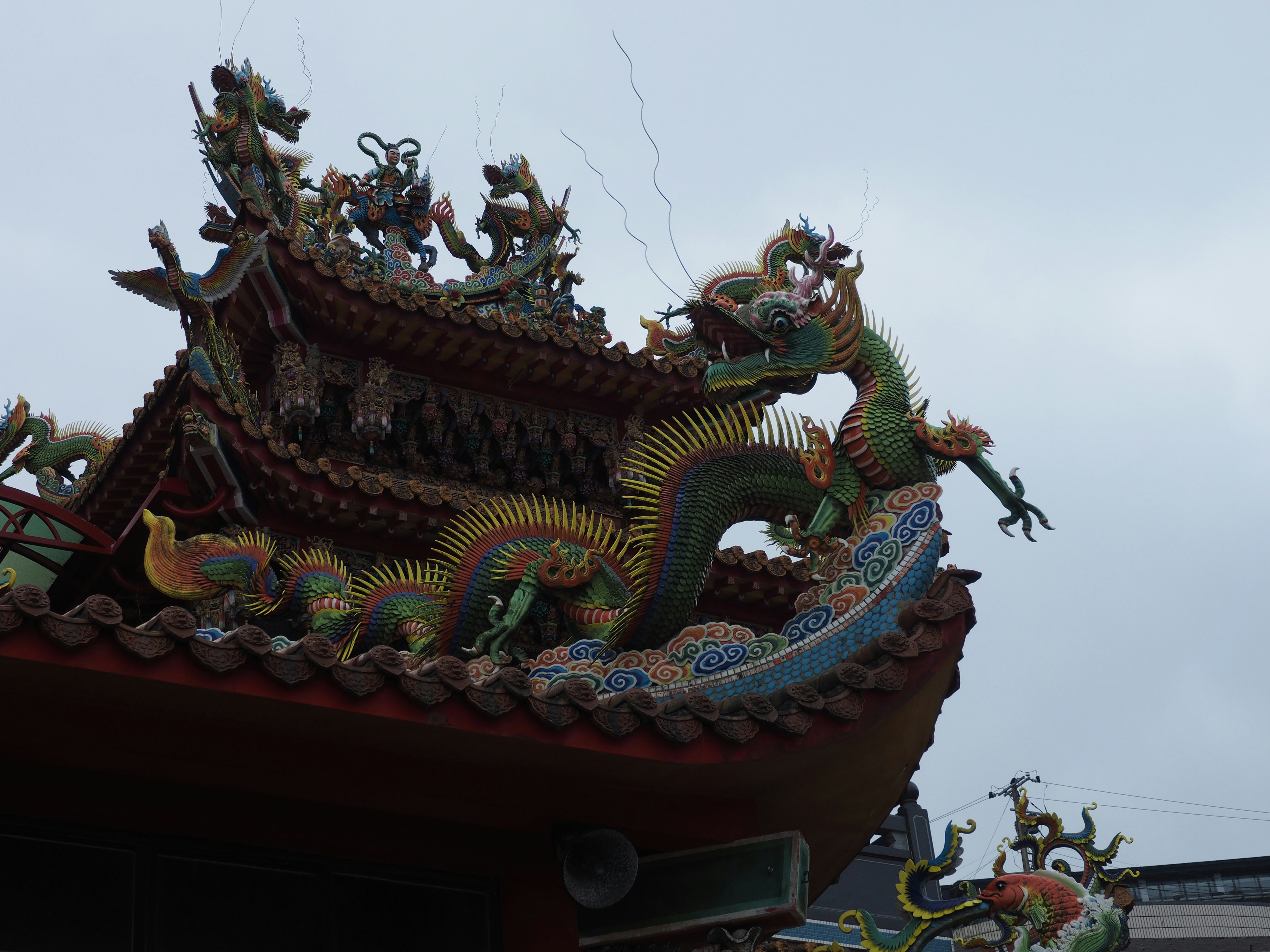 close view of a dragon-adorned temple roof against the sky
