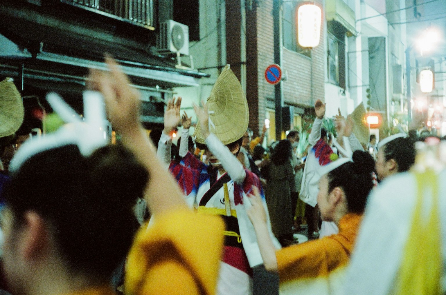 夜间节日中人们跳舞的生动场景 五彩缤纷的服装和举起的手