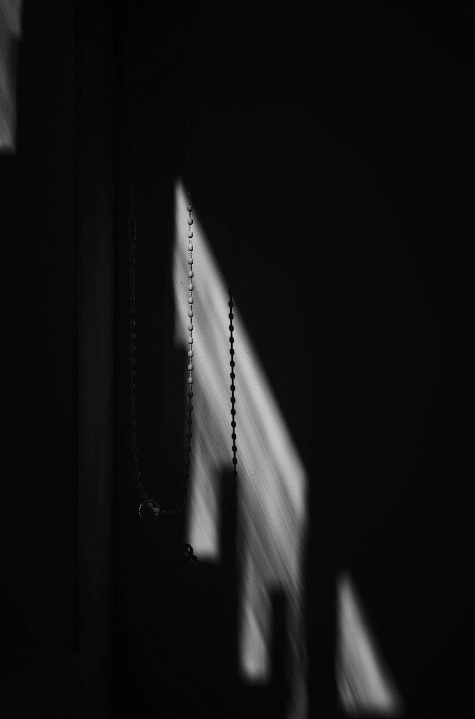 Lignes de lumière et détail de chaîne projetés dans l'ombre