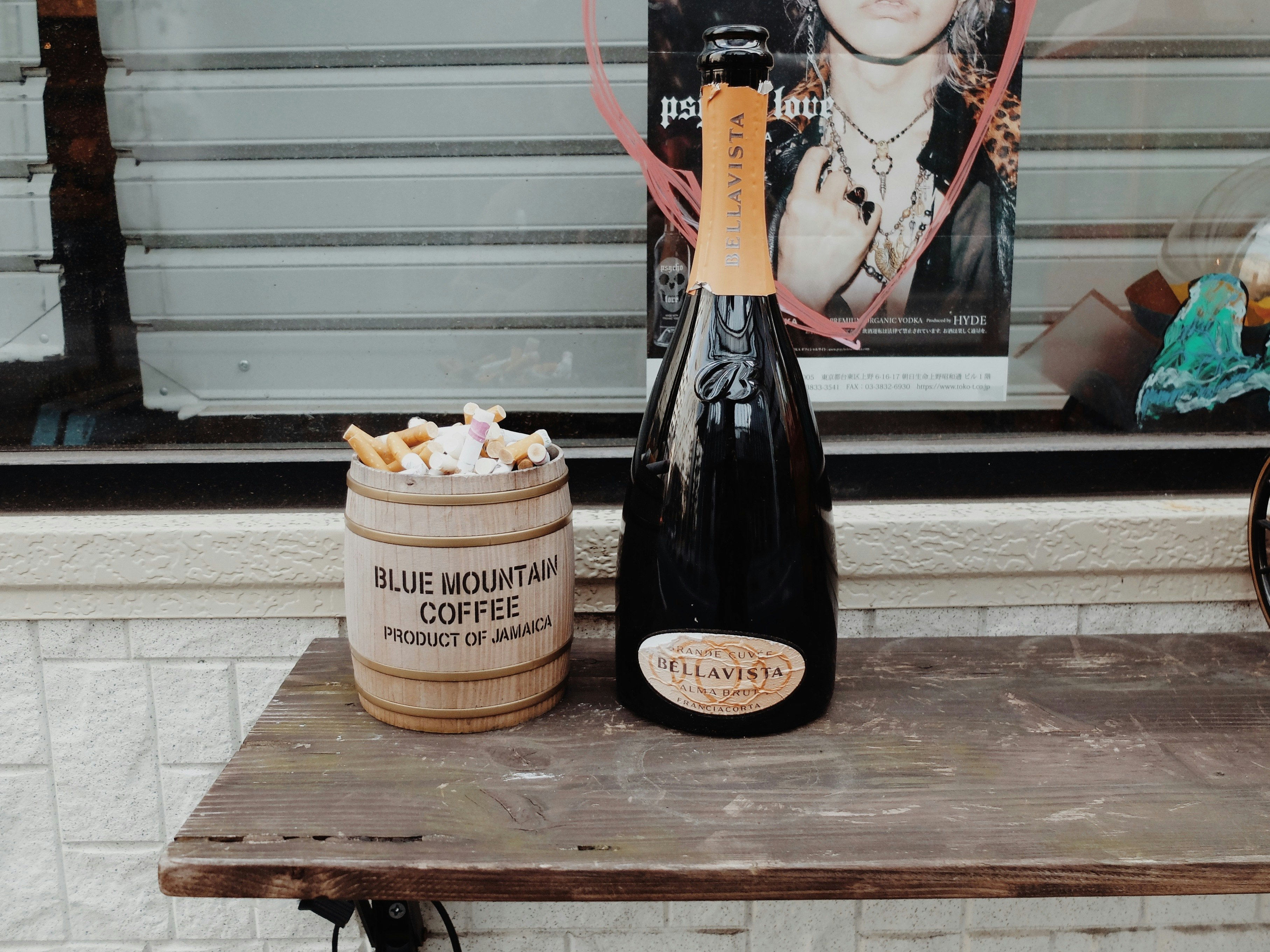 路地の屋外テーブルに置かれたコーヒーカップとボトル