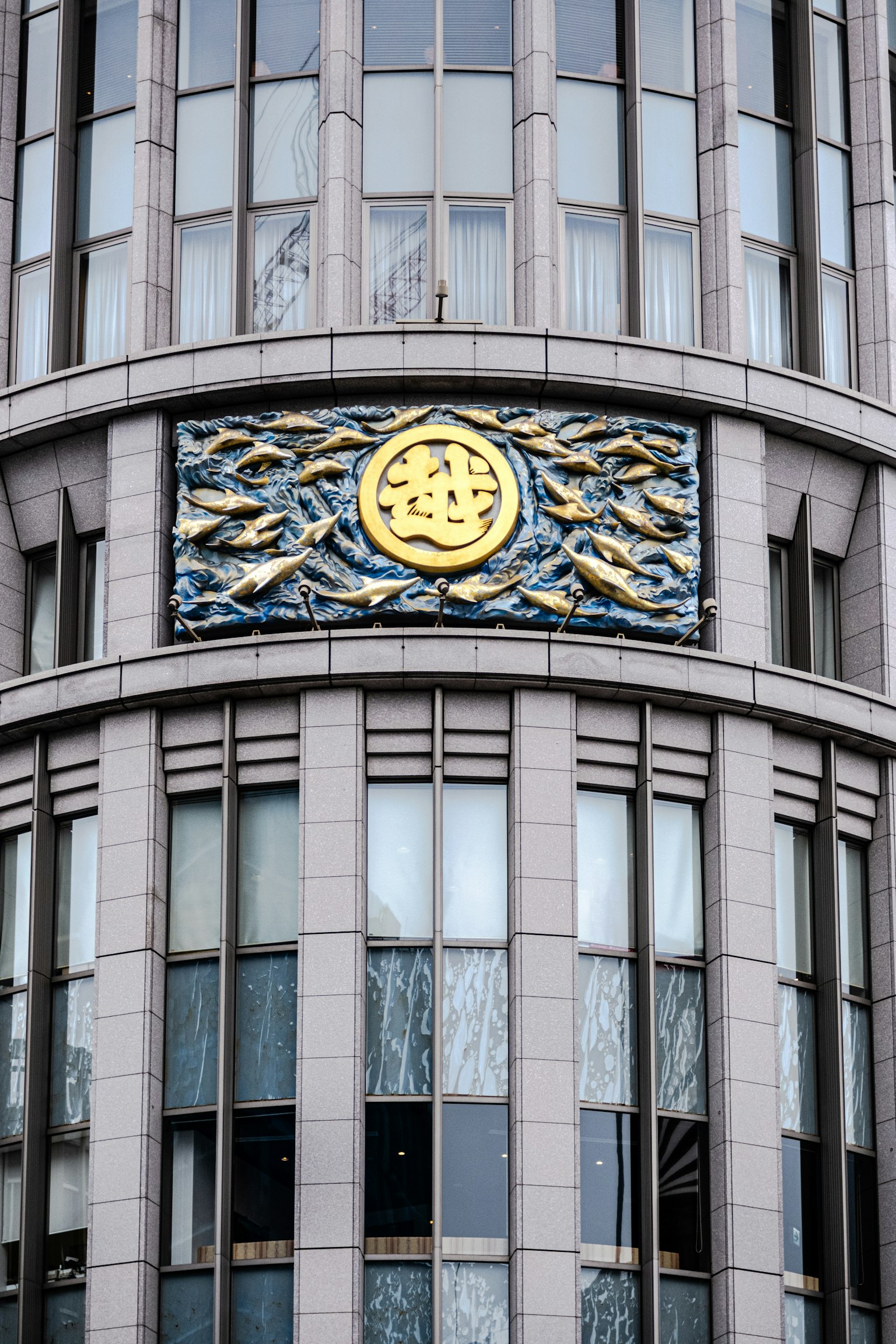 Emblème doré décoratif et motif de vagues sur la façade d'un bâtiment