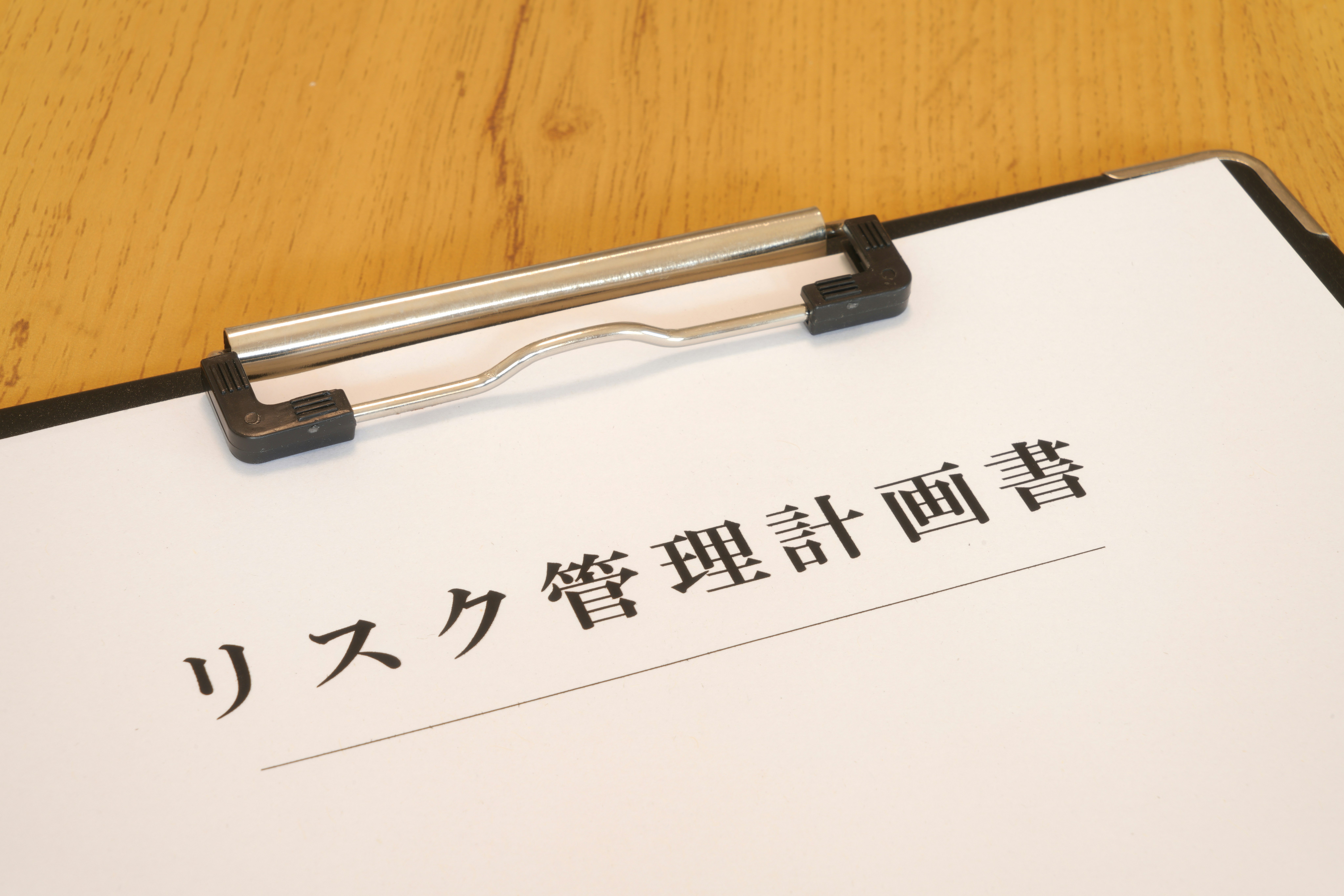 一个写有风险管理计划的夹子放在木桌上