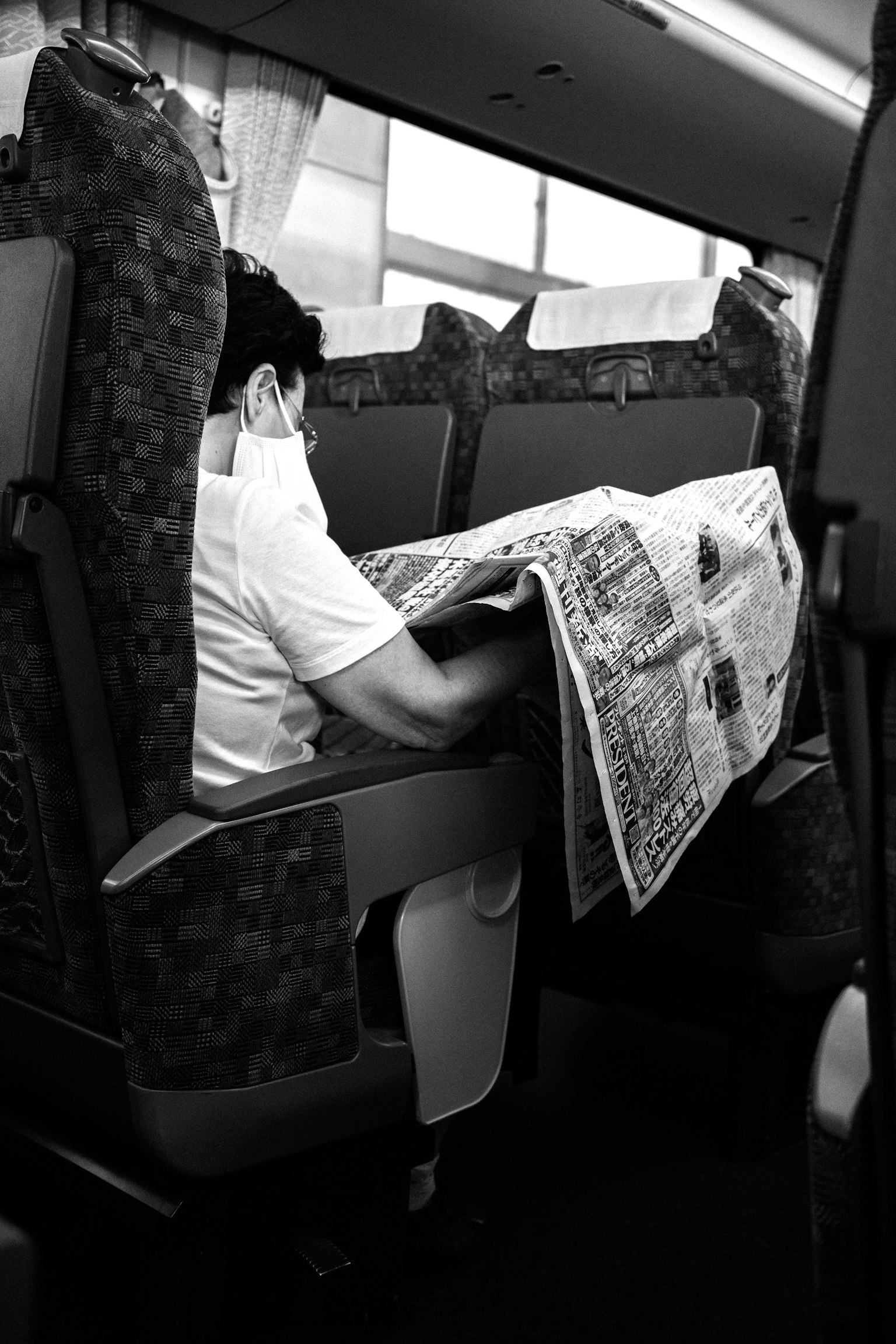 คนอ่านหนังสือพิมพ์บนที่นั่งรถบัส