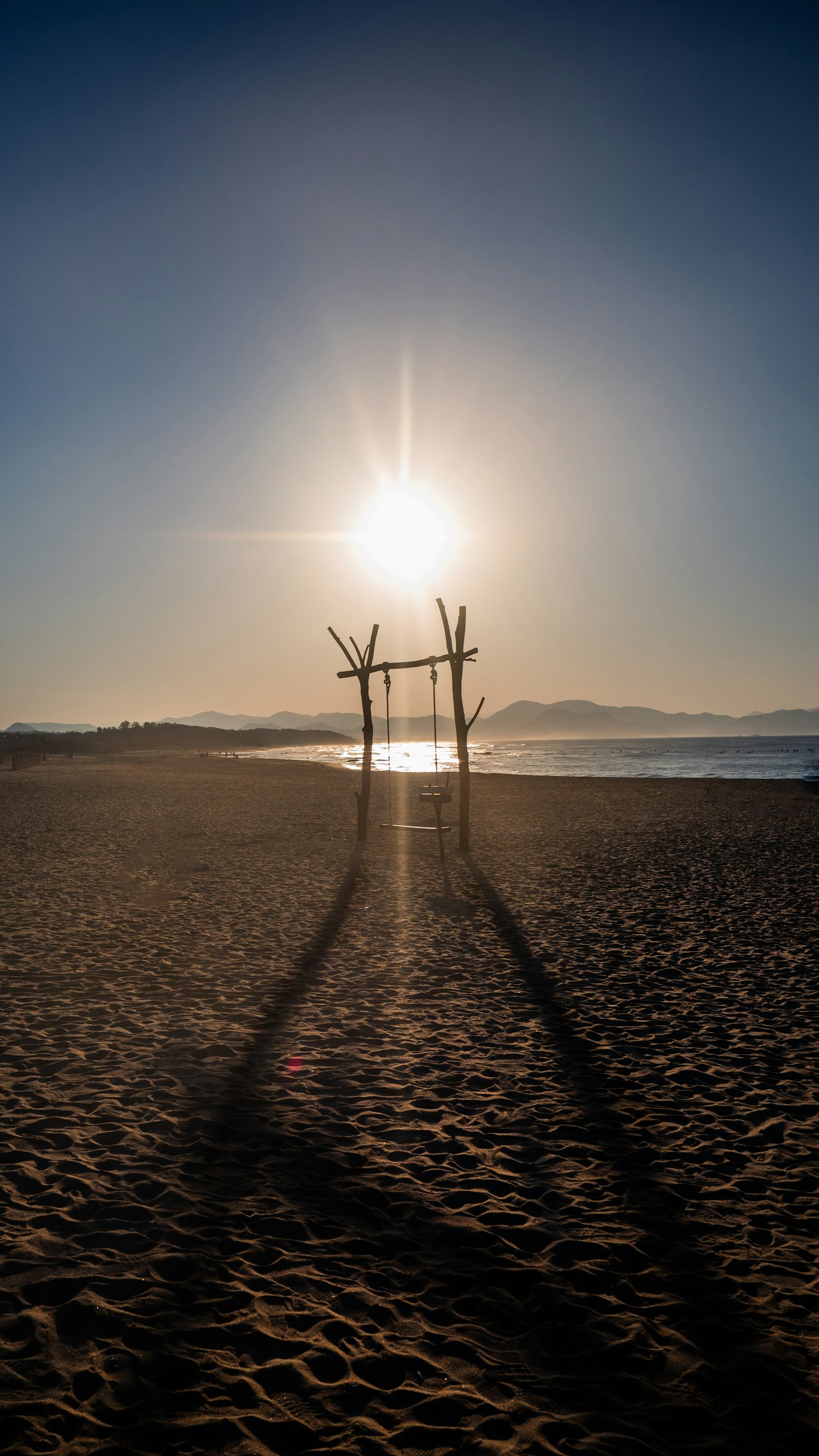 Marco de madera en la playa con el atardecer iluminando las sombras