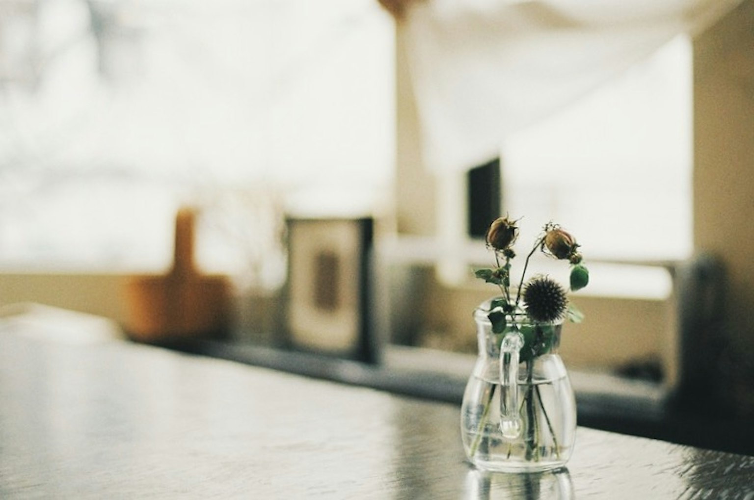 Small vase with flowers on a table in a softly lit interior