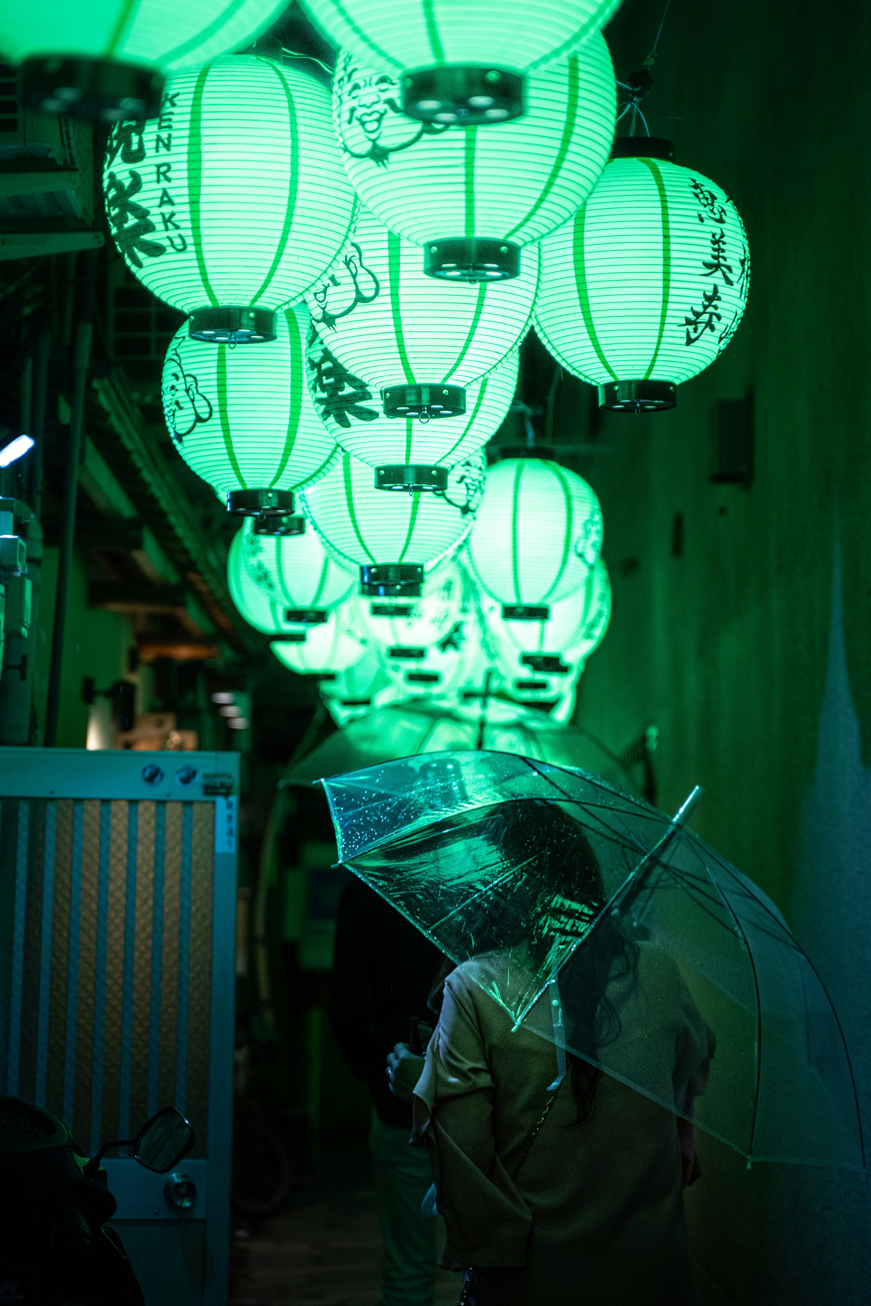 espacio de trabajo iluminado en verde con filas de drones esféricos y un operario