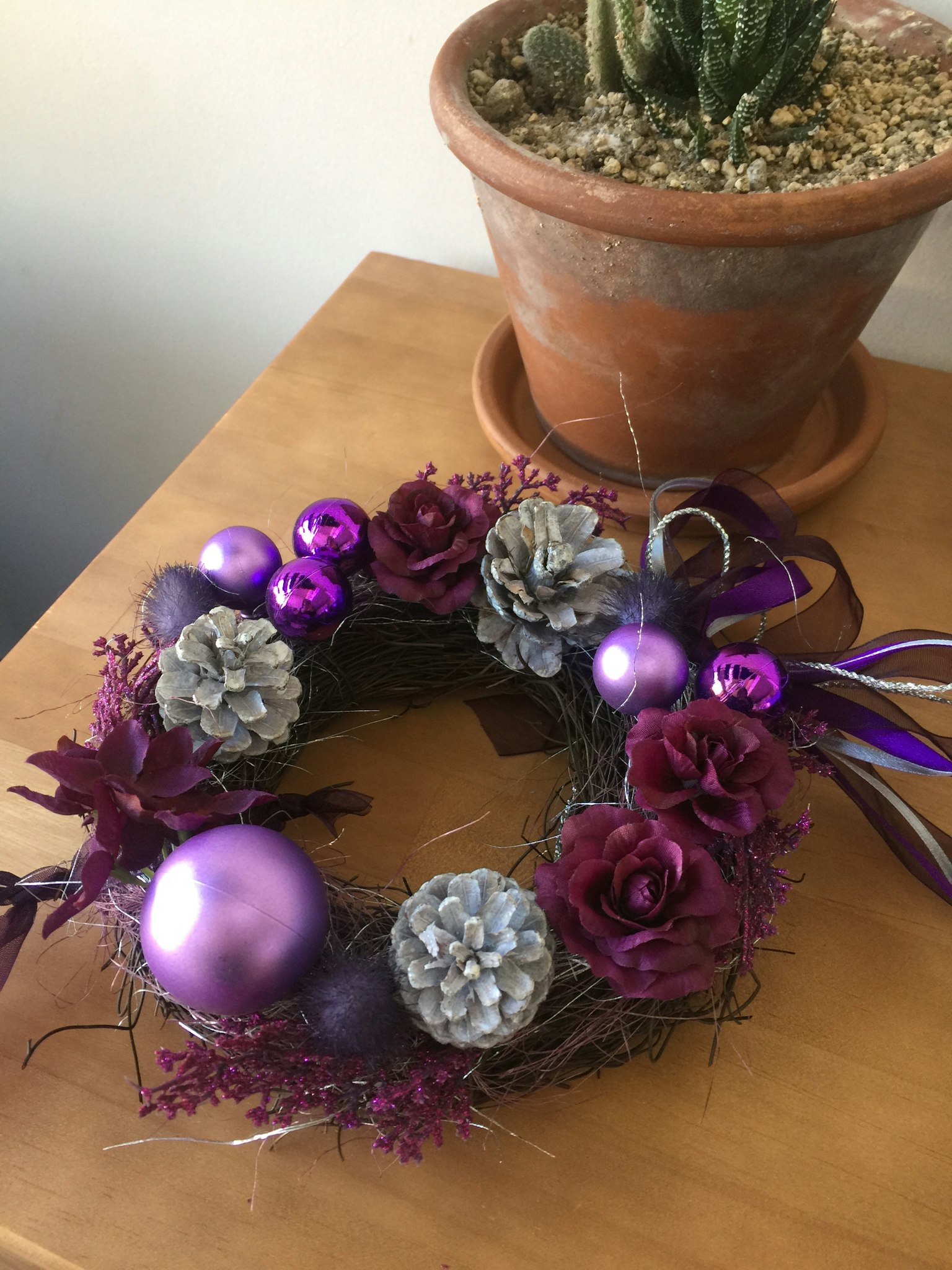 Wreath decorated with purple ornaments and pine cones