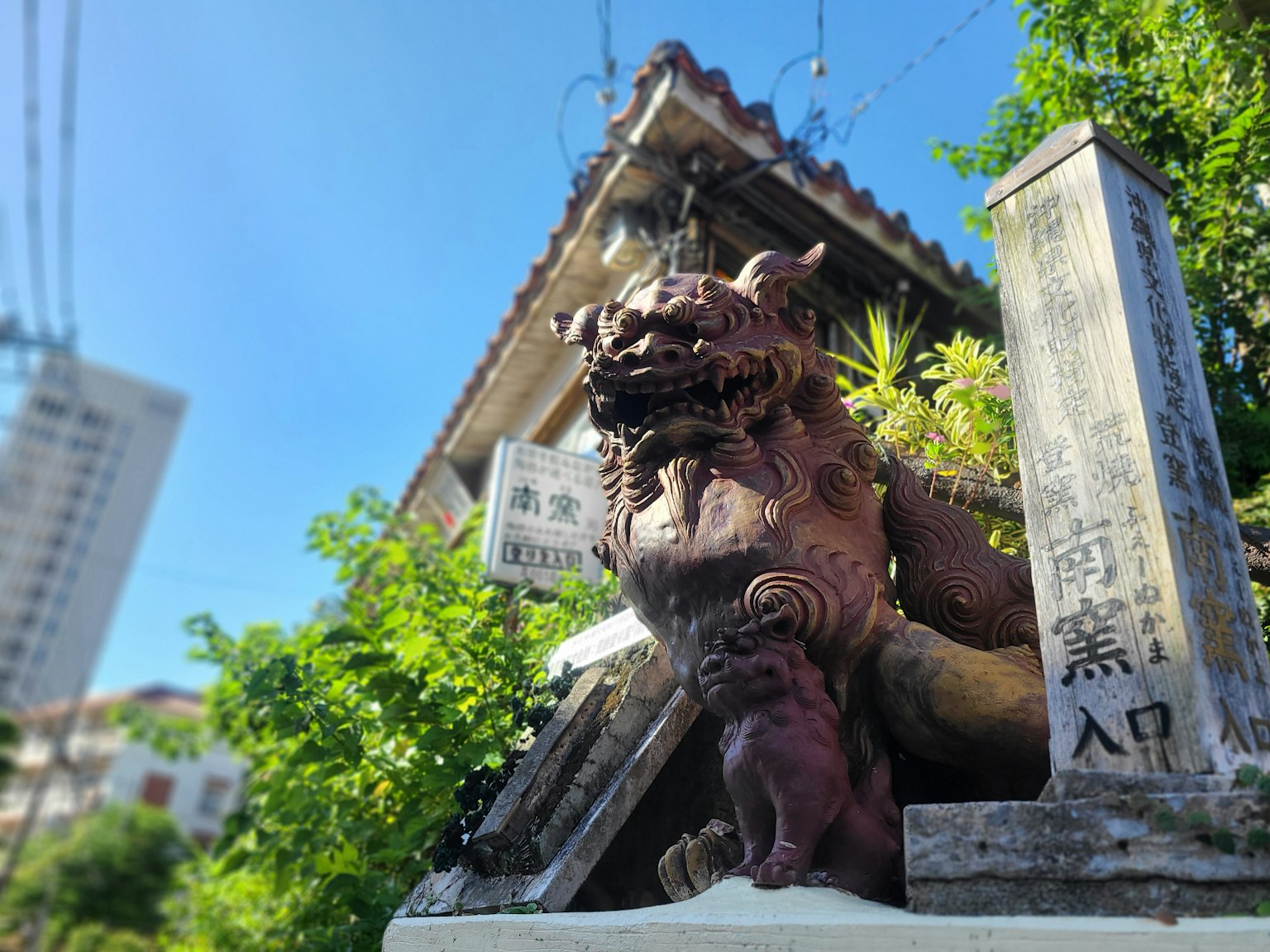 Statua di leone con un piccolo cucciolo all'ingresso di un santuario