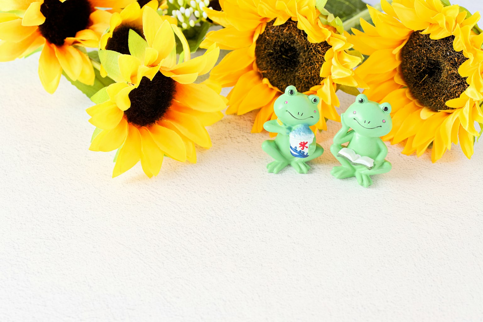 Heller Hintergrund mit gelben Sonnenblumen und grünen Froschfiguren