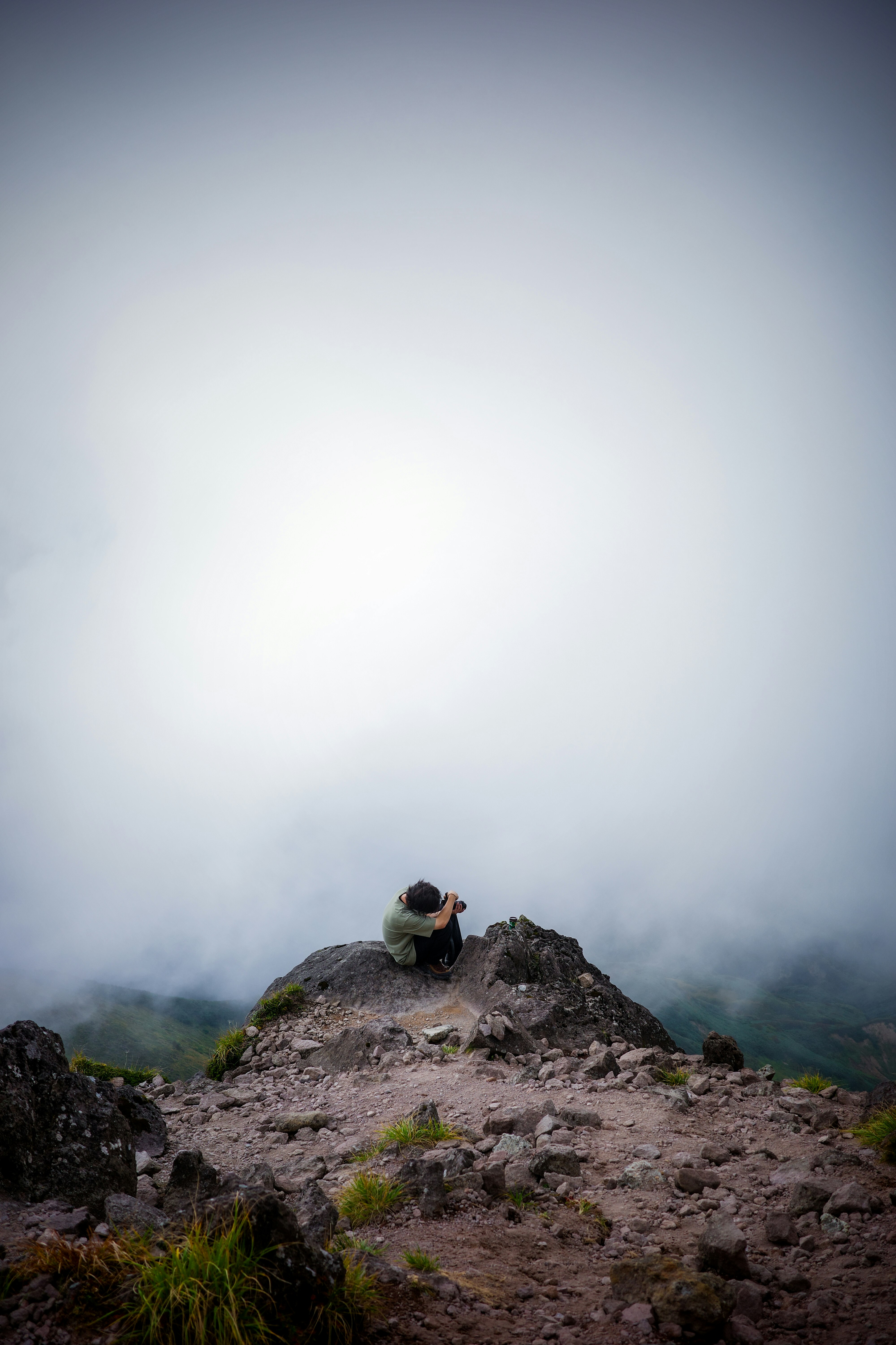 randonneur debout sur un sommet rocheux dans le brouillard