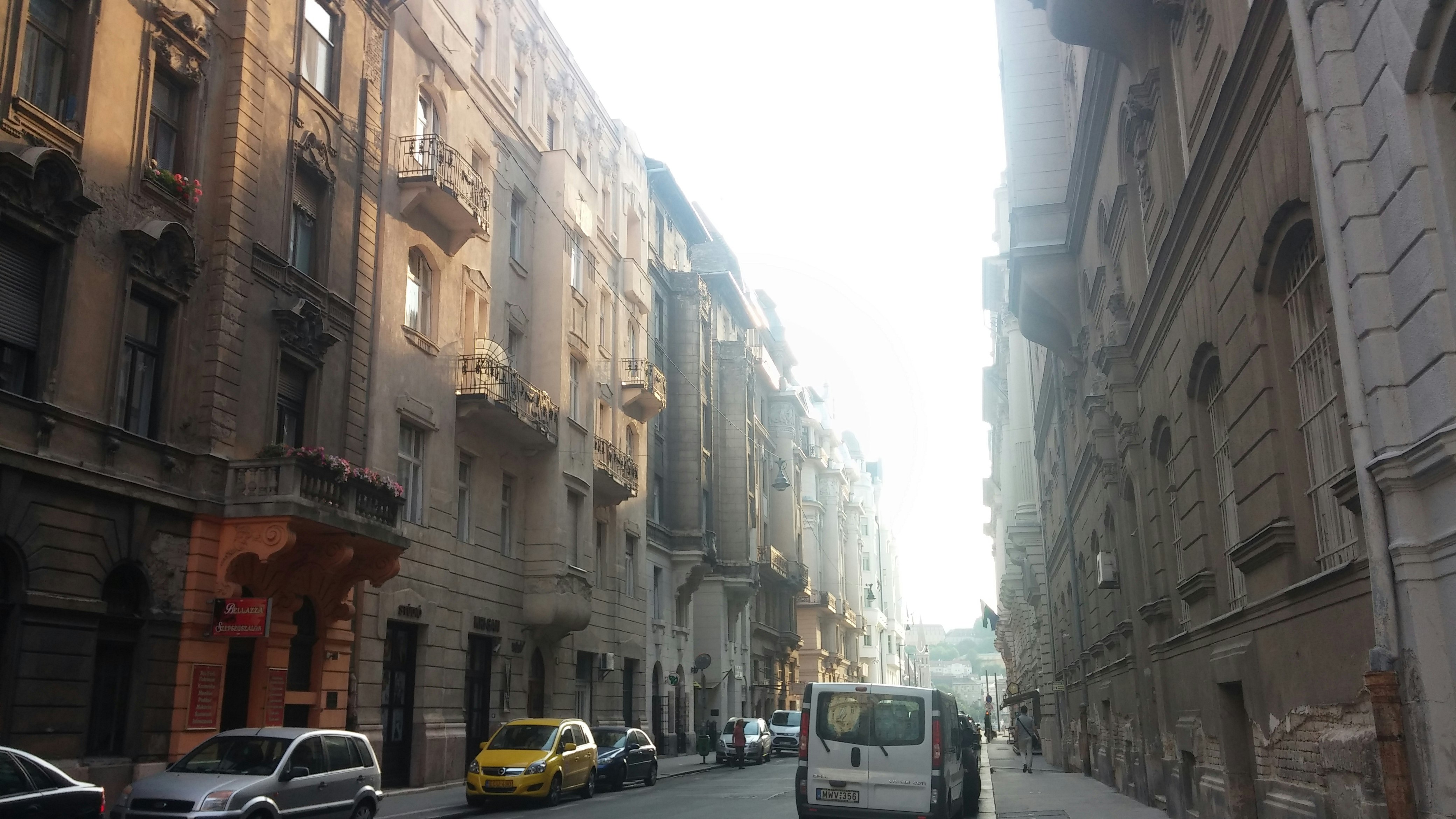 scorcio di strada con edifici in pietra e auto