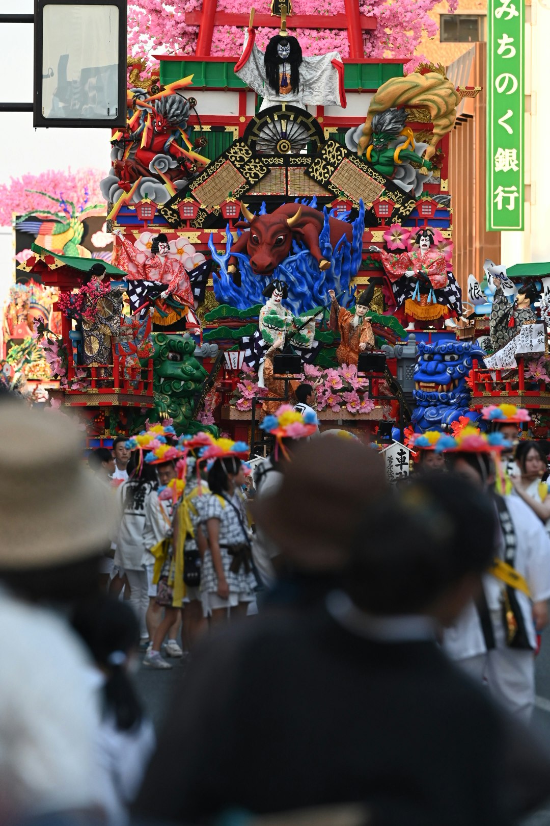 色鮮やかな人形や飾りが並ぶ祭りの屋台と参拝客の行列