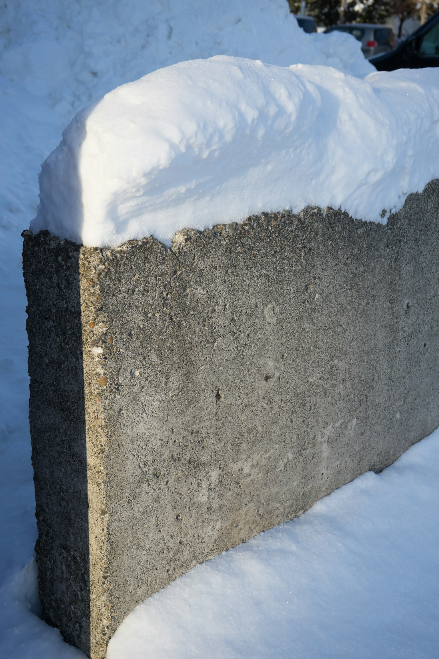 Part of a concrete wall covered with snow