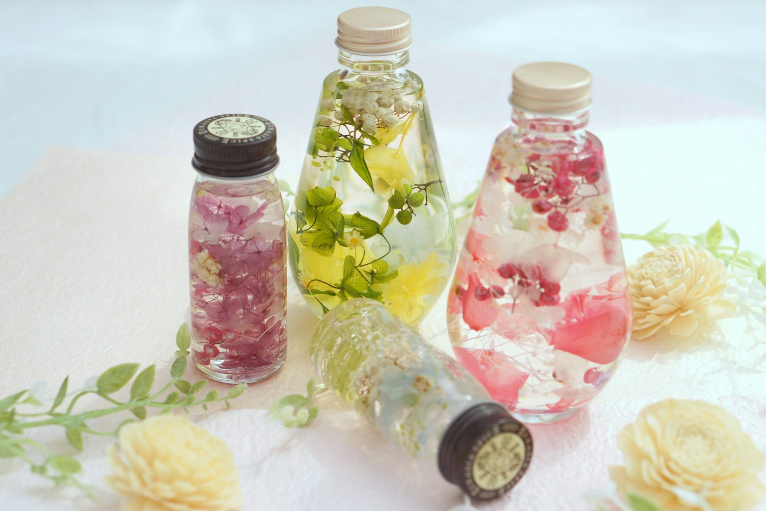 Những chai thảo dược đầy màu sắc được sắp xếp với hoa và lá