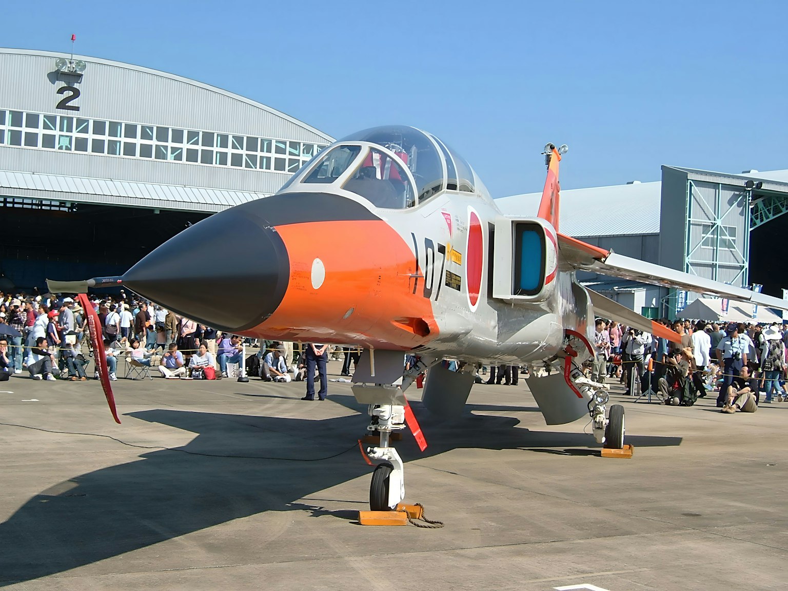 Un avion militaire exposé lors d'un salon aéronautique avec une foule en arrière-plan