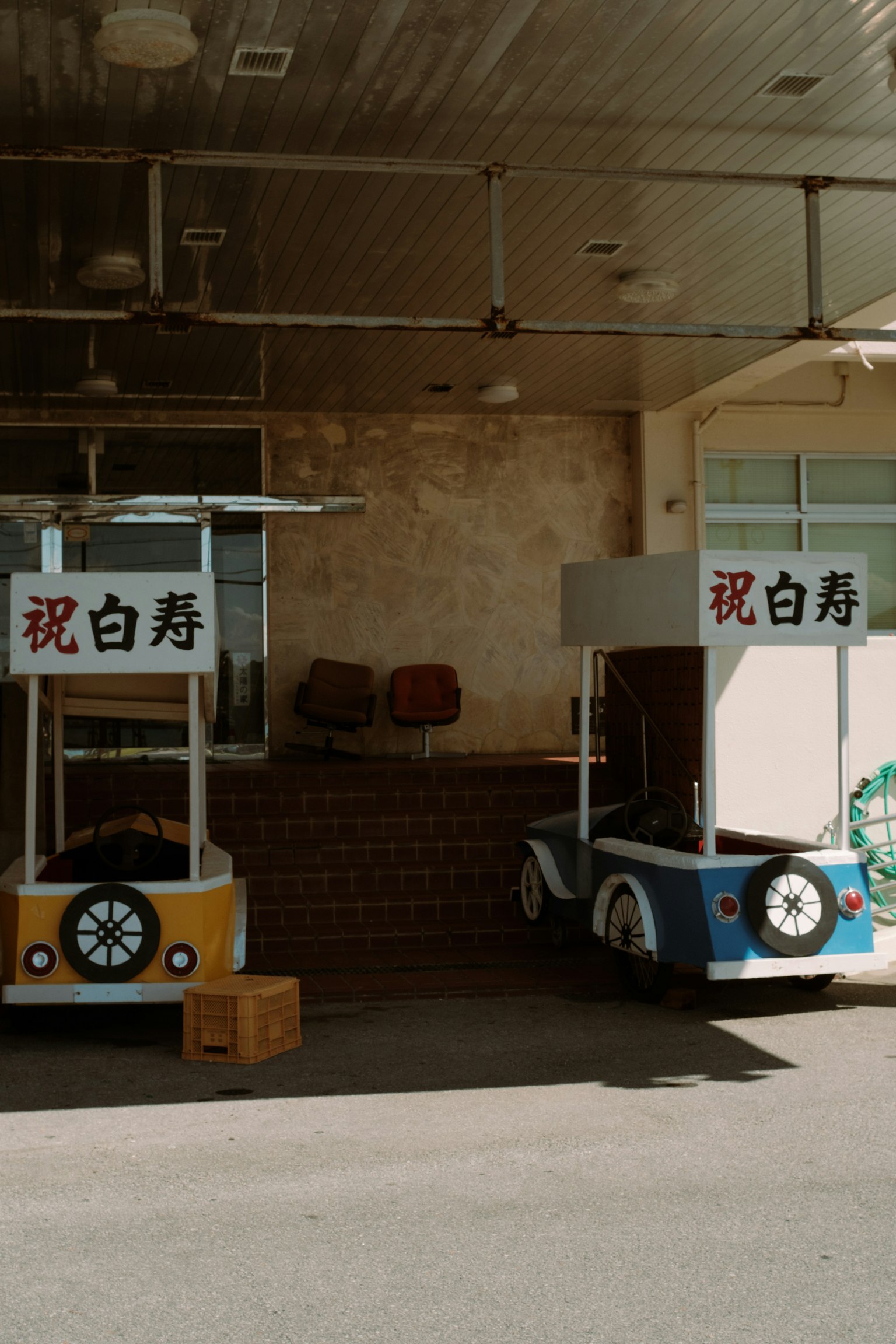 Two uniquely designed carts parked outside a building