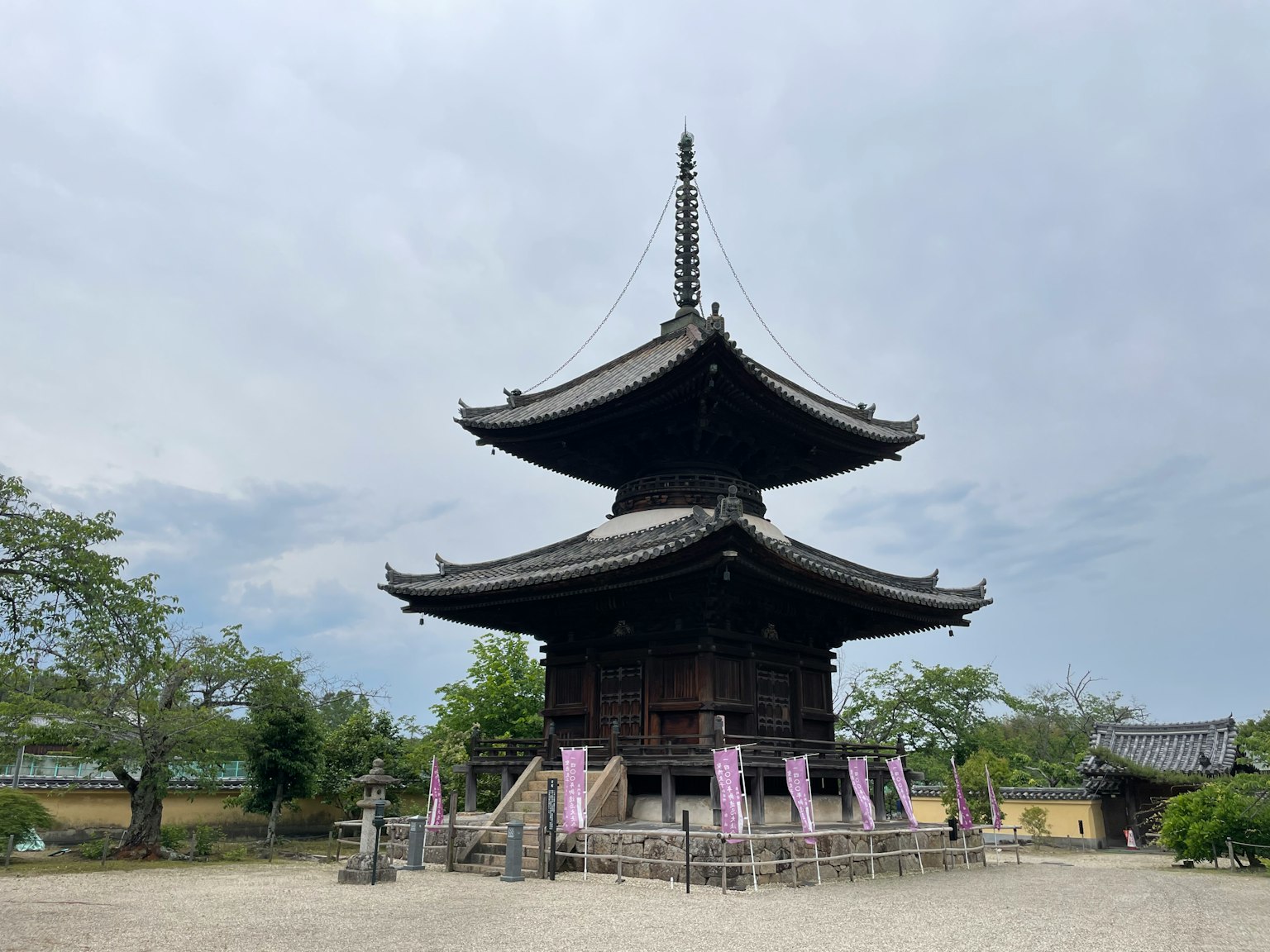Pagoda kuil Jepang yang indah, struktur kayu, menonjol di latar belakang langit kelabu