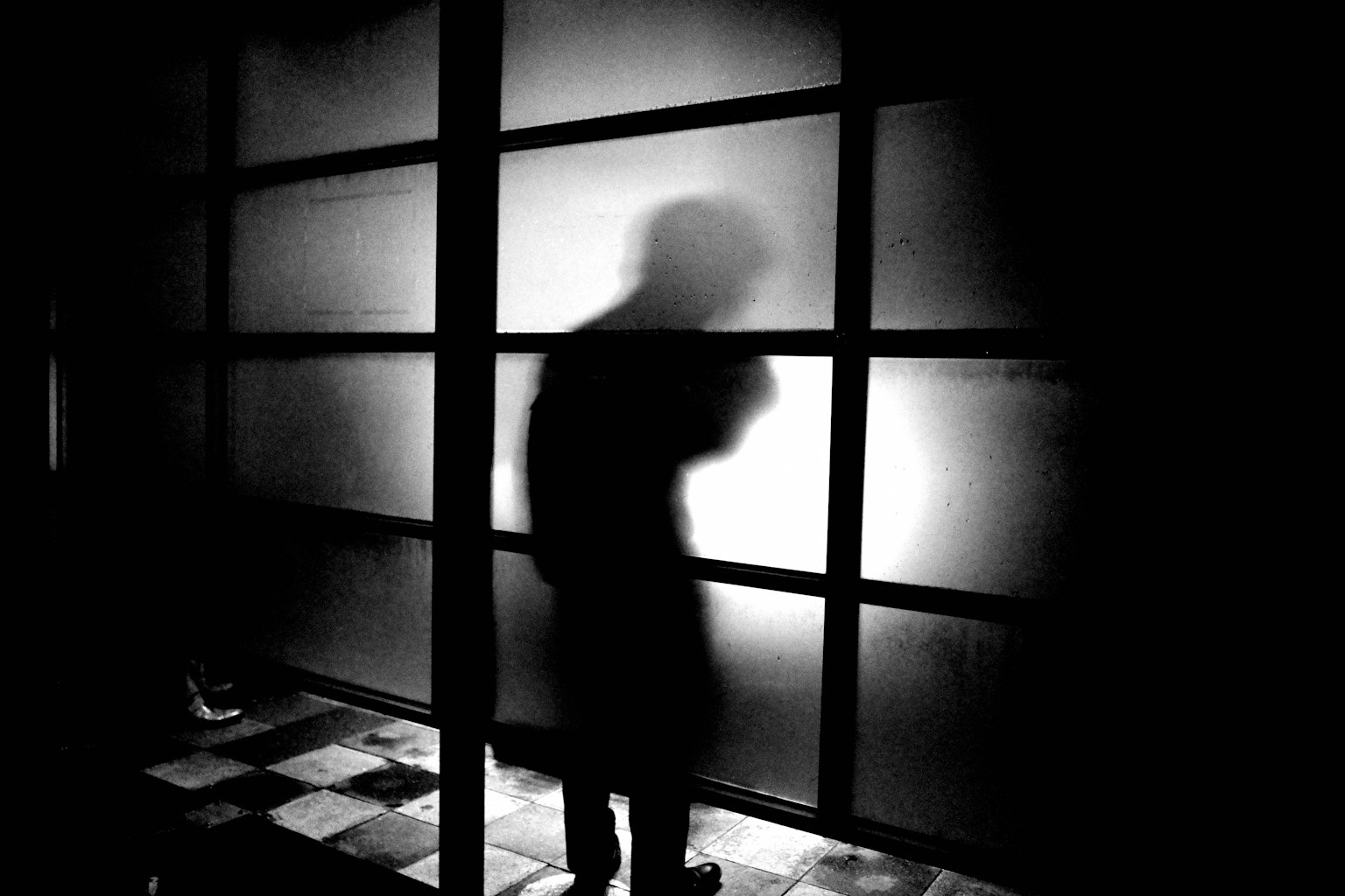 Silueta de una persona contra un fondo oscuro en blanco y negro