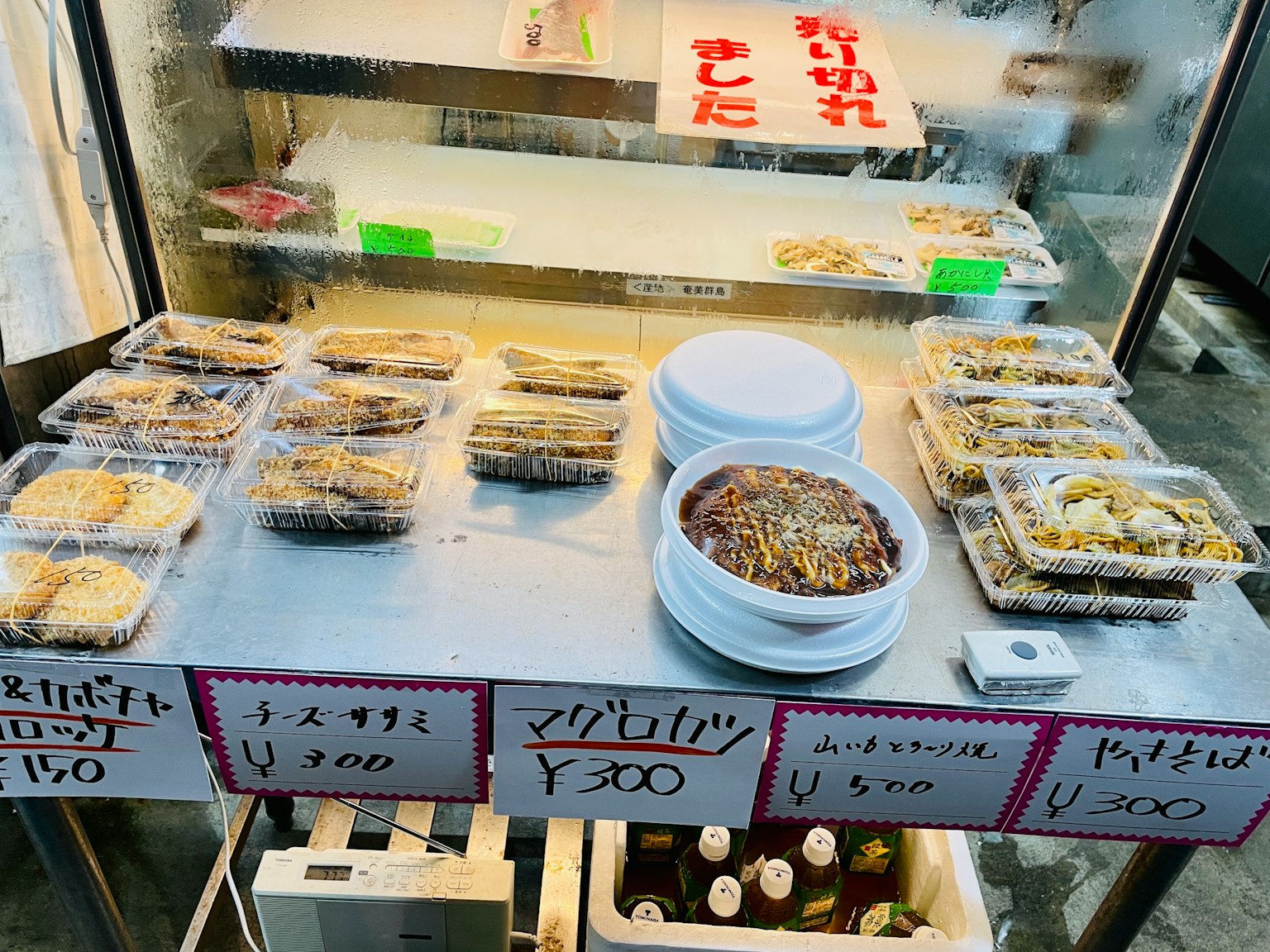 อาหารญี่ปุ่นจัดแสดงบนโต๊ะพร้อมป้ายราคา