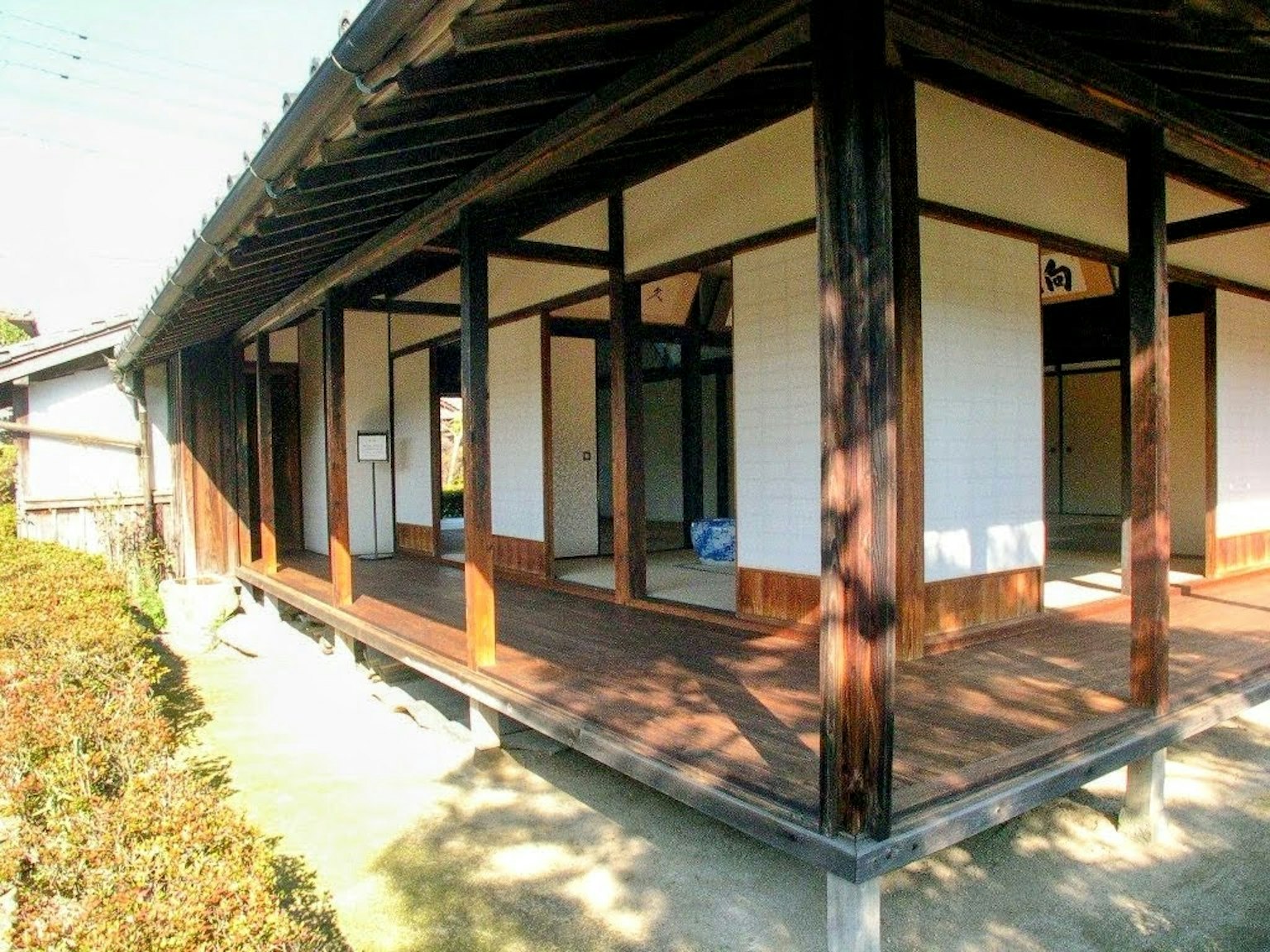 Extérieur d'une maison japonaise traditionnelle avec une structure en bois et des écrans shoji