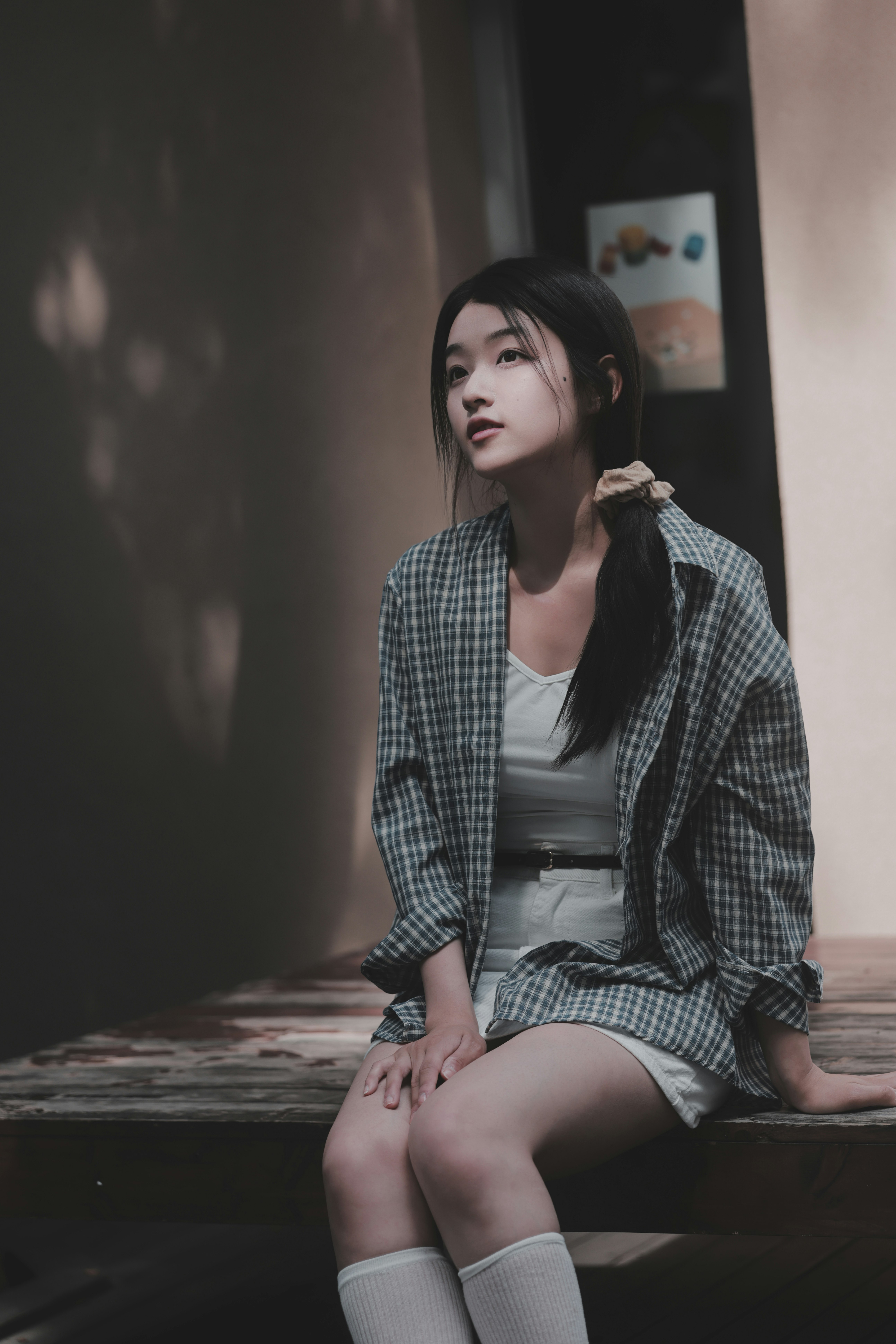 woman in a checkered shirt sitting on a bed