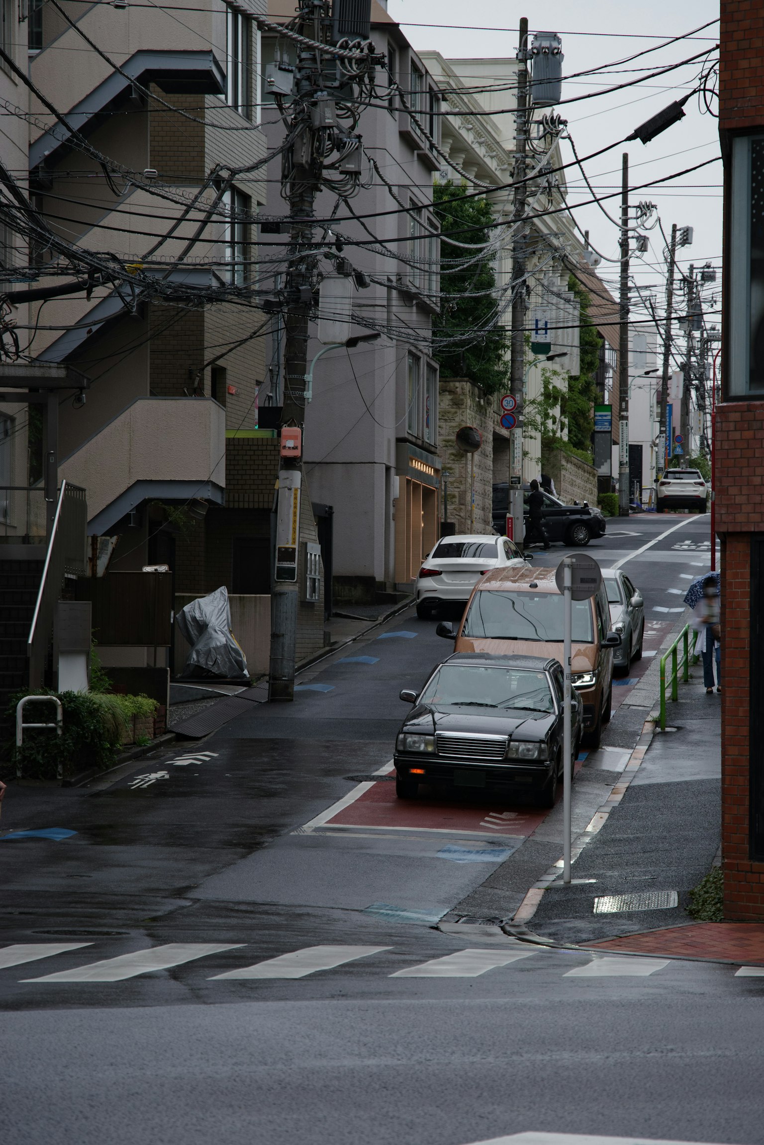 狹窄的雨水浸潤街道與汽車和周圍建築