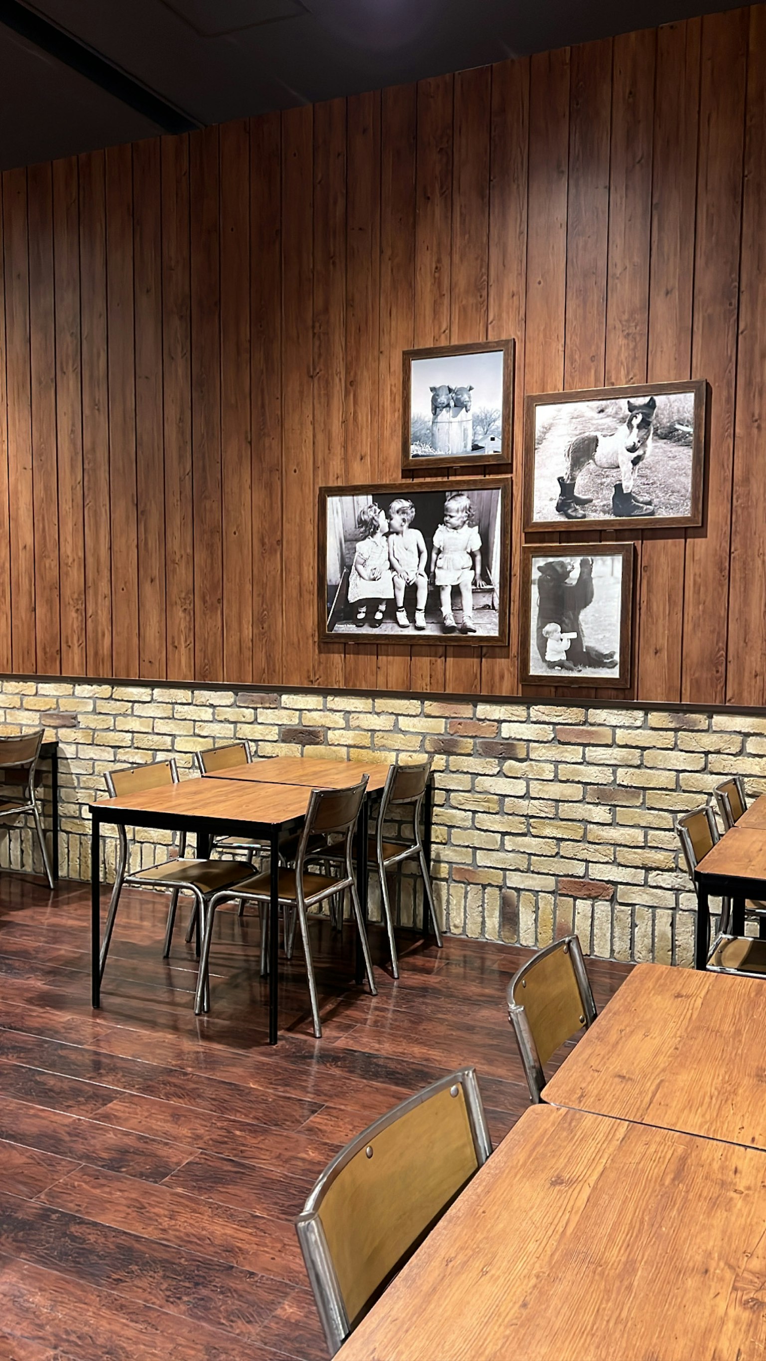 Interno di un caffè accogliente con pareti in legno e accenti in mattoni Foto in bianco e nero decorano il muro