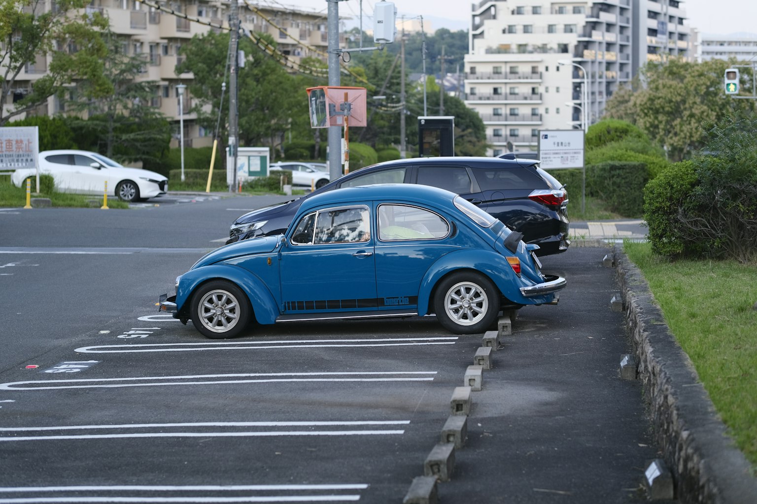 Une coccinelle bleue garée dans un parking