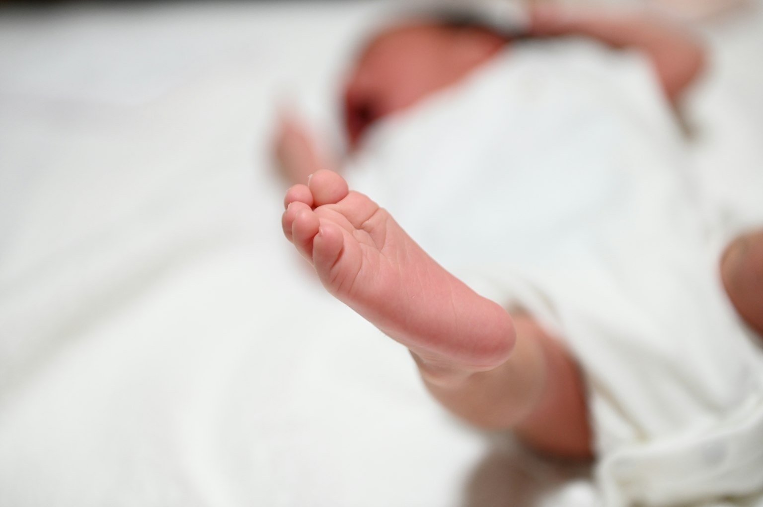 Kaki bayi baru lahir di atas kain putih
