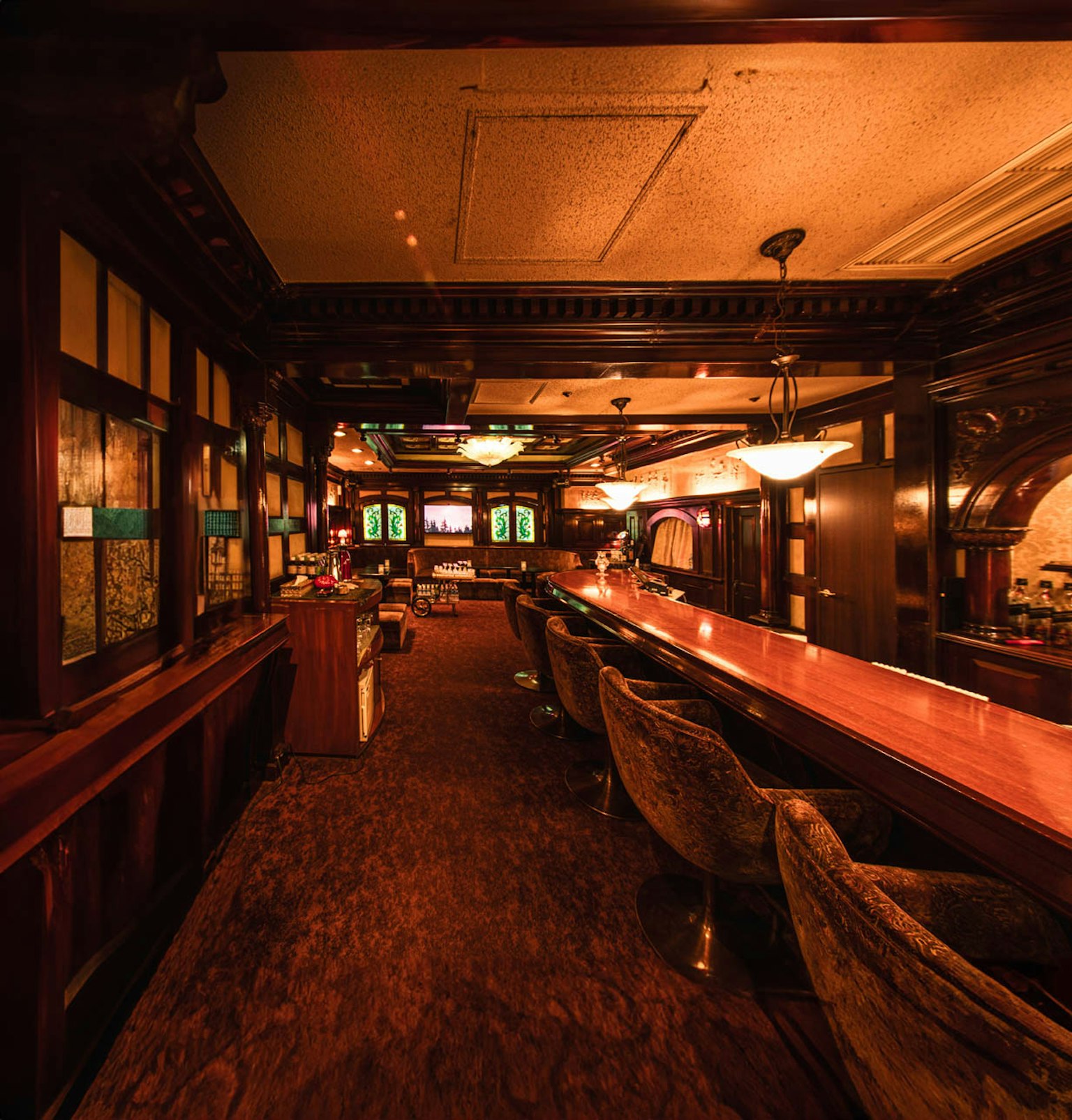 Intérieur d'un bar chaleureux avec un long comptoir et des sièges confortables