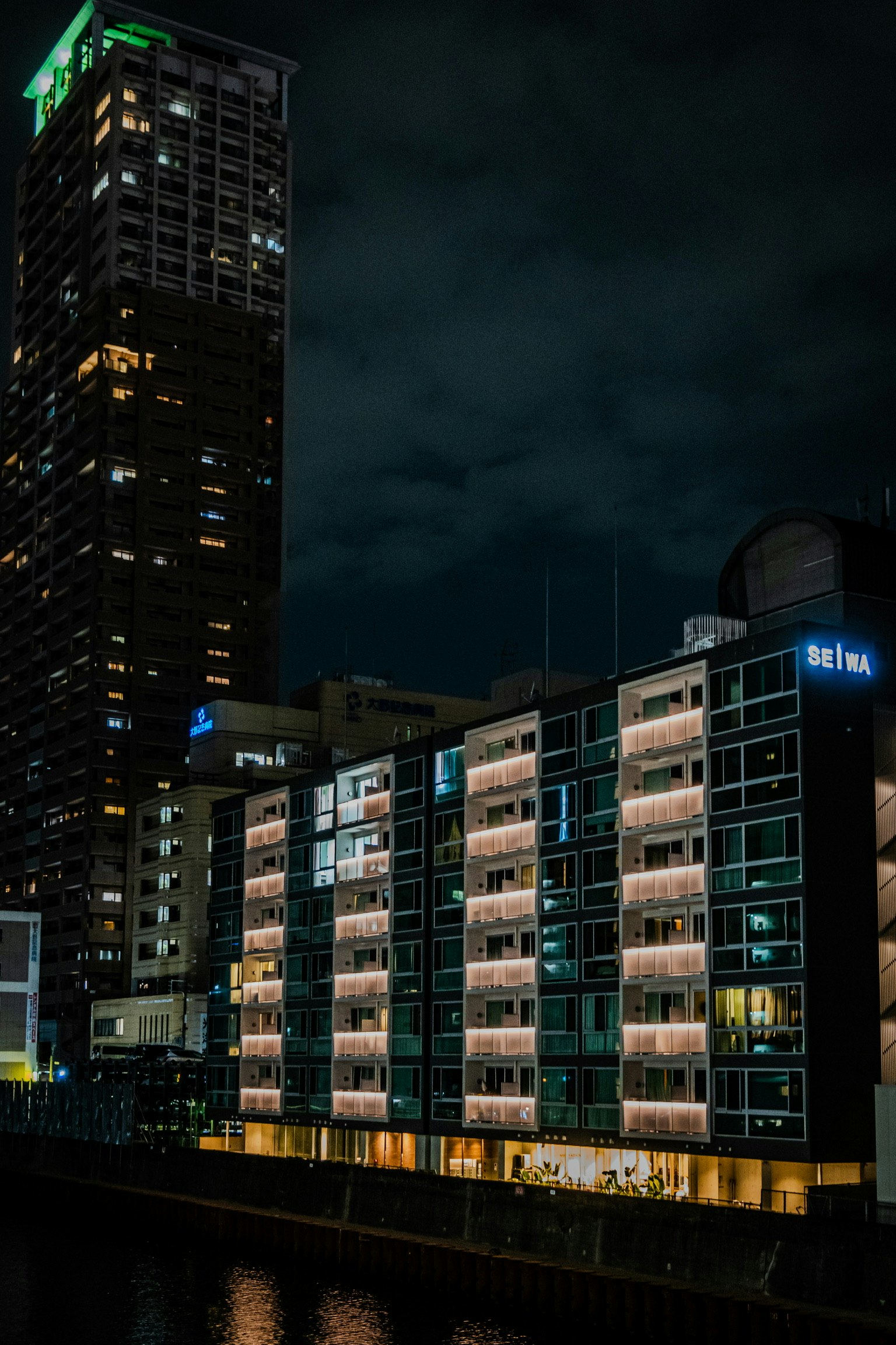 Contrasto tra un grattacielo e appartamenti a bassa altezza in un paesaggio urbano notturno