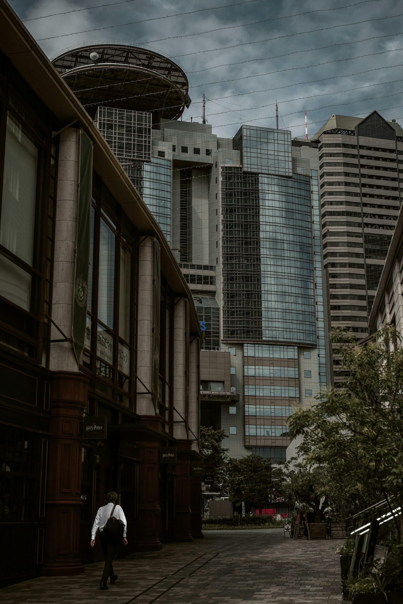 Urban landscape with towering skyscrapers and a person walking in the foreground