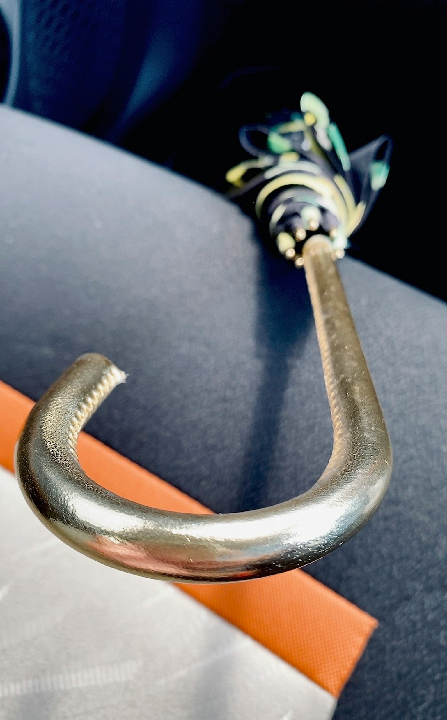 Primo piano del gancio di un ombrello appoggiato su una superficie