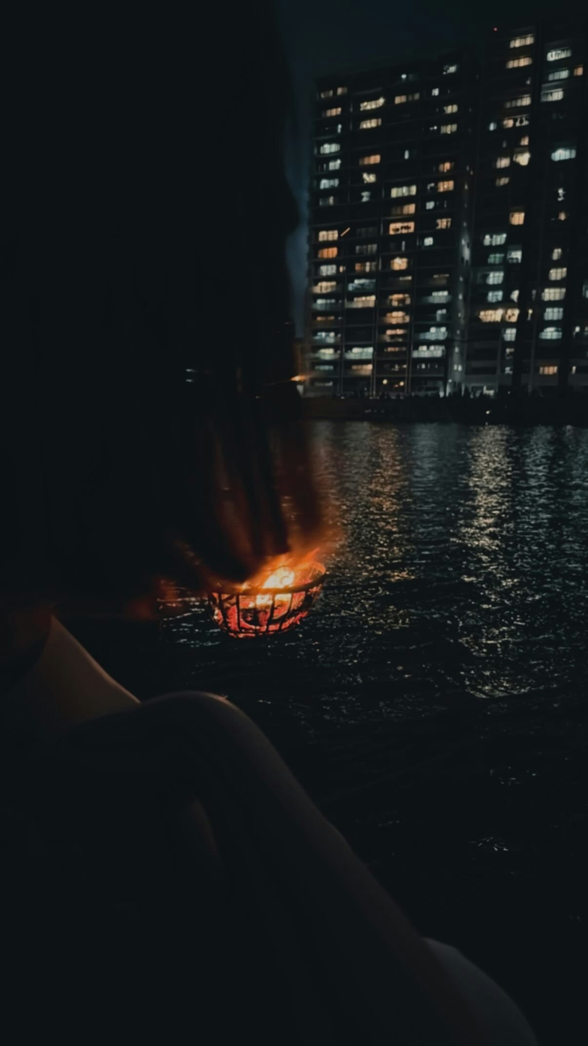 夜晚水岸景色，燈火點點的船隻與高樓